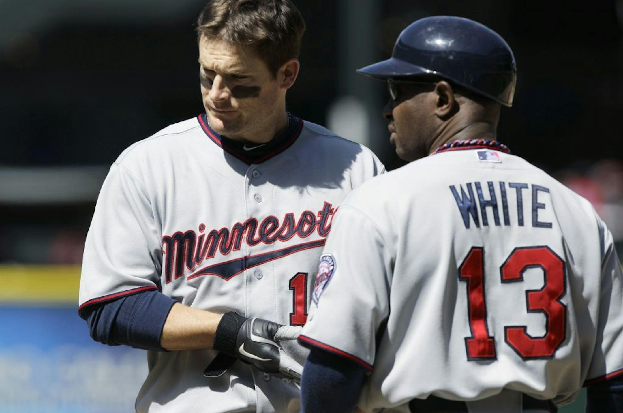 Minnesota Twins' Josh Willingham, left, stands next to first base coach Jerry White after Willingham grounded out to end the sixth inning of a baseball game against the Seattle Mariners, Sunday, May 6, 2012, in Seattle. The Mariners won 5-2.