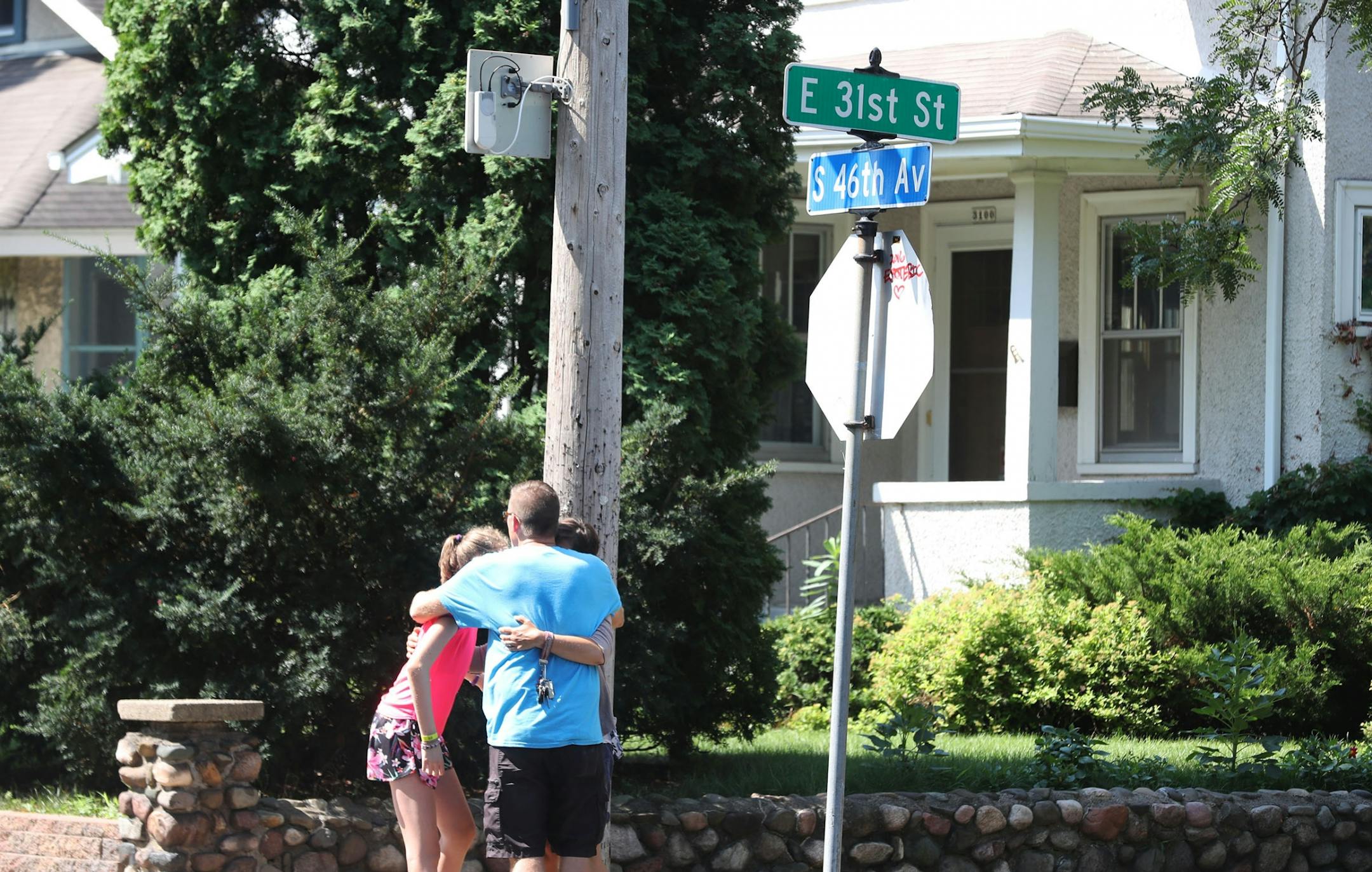 At least one person is dead following an explosion and building collapse at Minnehaha Academy. Here, family members hug under a street sign, near the explosion site Wednesday, Aug. 2, 2017, in Minneapolis, MN.