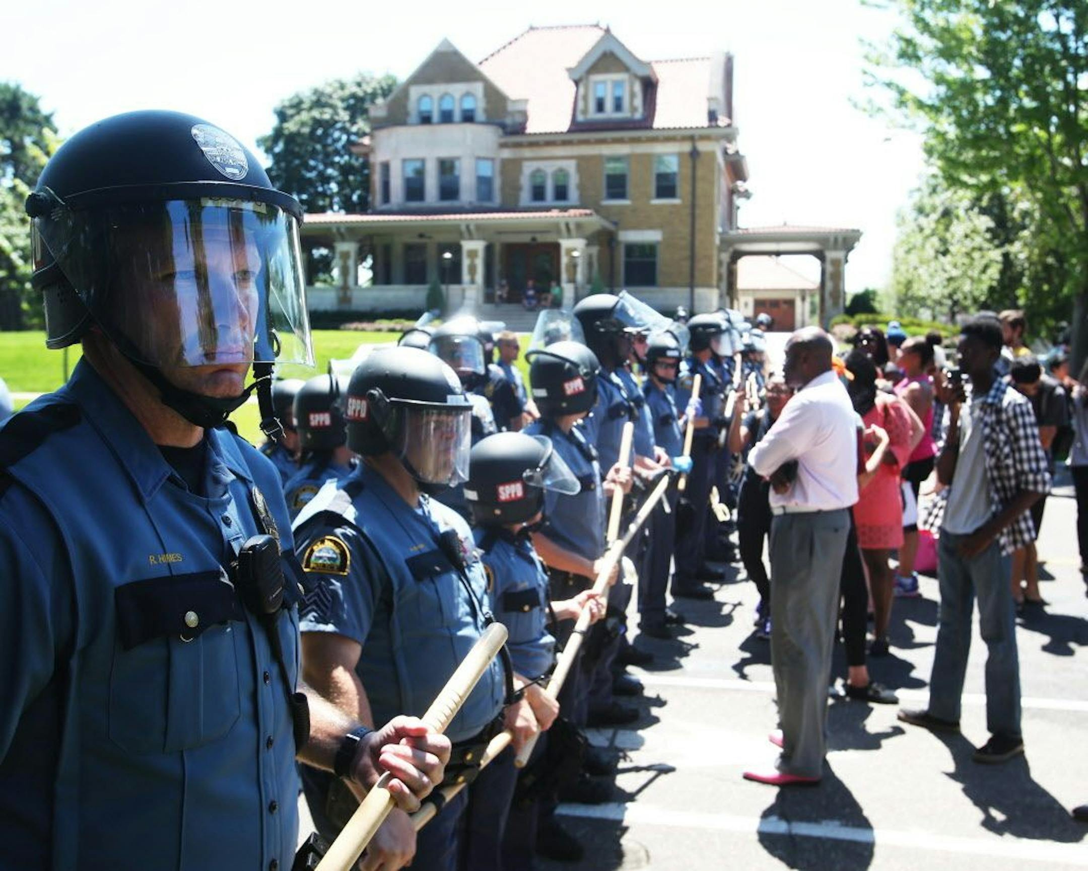 Protestors and St. Paul police officers face off at Oxford and Summit Ave. following arrests of protestors outside Gov. Mark Dayton's mansion Tuesday, July 26, 2016, in St. Paul, MN.