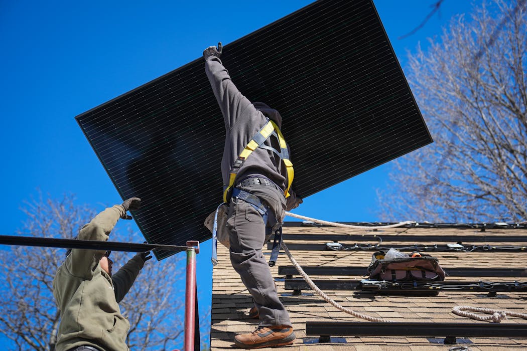 Workers from TruNorth Solar install a rooftop solar panel power system in Golden Valley. 