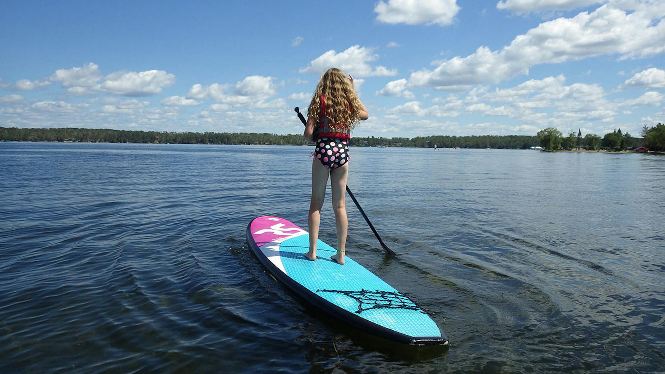 Kylie McClintick tries stand-up paddle boarding on Steamboat Bay at Madden's Resort.
