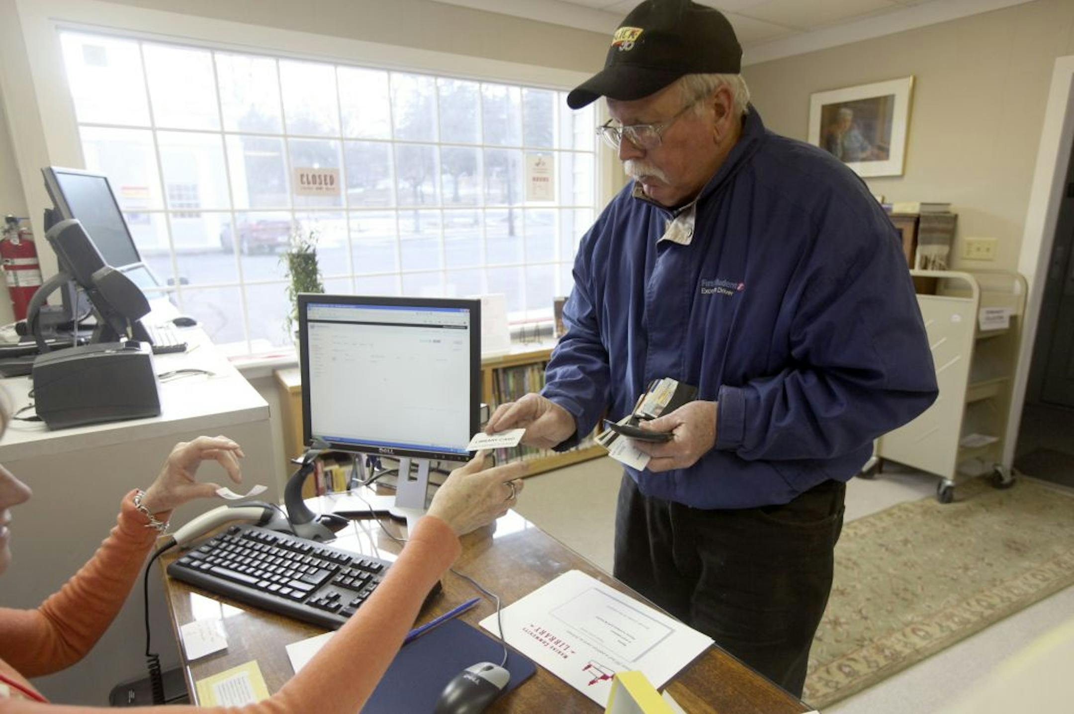Volunteer Deb Yanker Black gave James Wirth back his library card with his new sticker for the Marine St. Croix Library,in Marine on St. Croix Min., Tuesday, February 7, 2012.