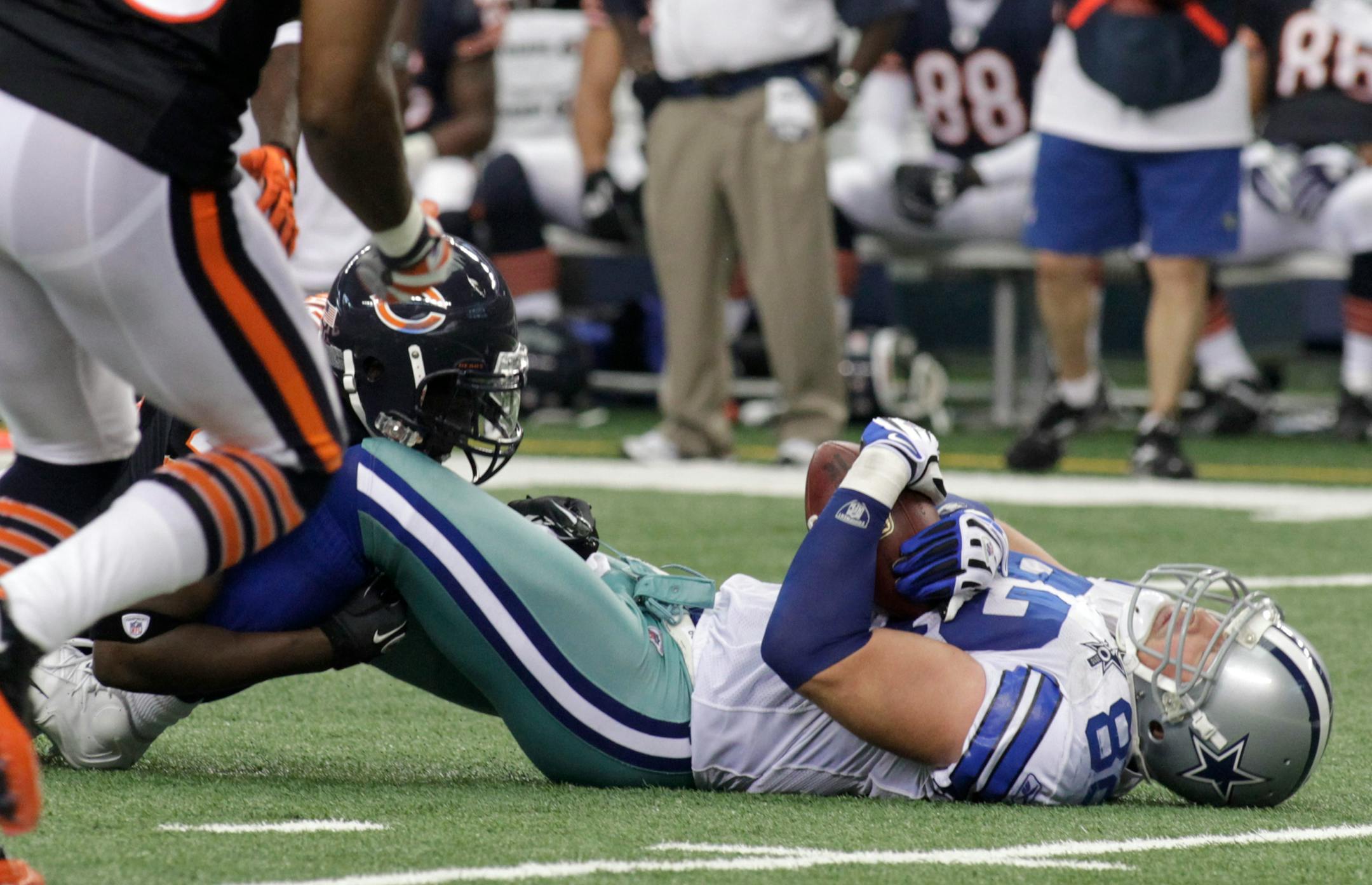 Dallas Cowboys tight end Jason Witten, right, lies on the ground after being stopped by Chicago Bears defenders, including safety Chris Harris, left, in the second half of an NFL football game Sunday, Sept. 19, 2010, in Arlington, Texas. (AP Photo/Sharon Ellman)