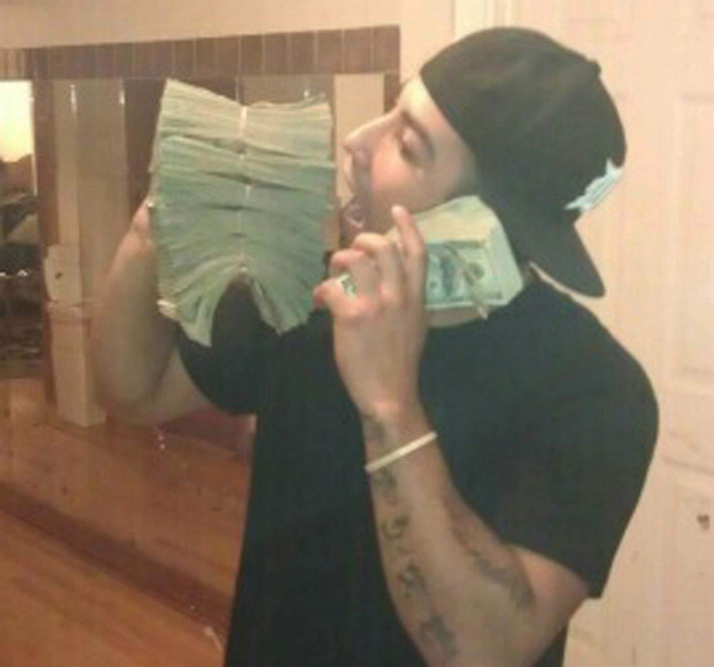 Drug Trafficker Fernando Cabanas kissing stacks of cash reaped from selling heroin in the Twin Cities via a Chicago connection with the Latin Kings street gang in 2012. Photo was taken off Cabanas&#x201a;&#xc4;&#xf4; cell phone following his arrest. He was convicted.