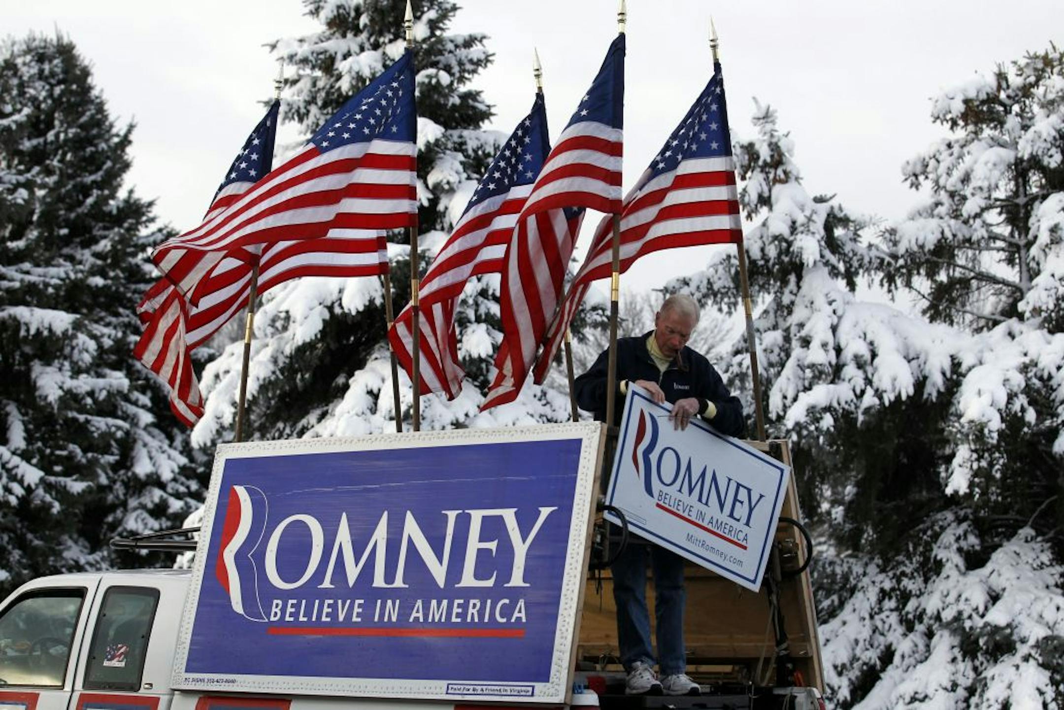 Jim Wilson, a supporter of Republican presidential candidate, former Massachusetts Gov. Mitt Romney, lashes American flags to the back of his pickup truck before Romney speaks at the Ingham Lincoln Day Breakfast in Lansing, Mich., Saturday, Feb. 25, 2012.