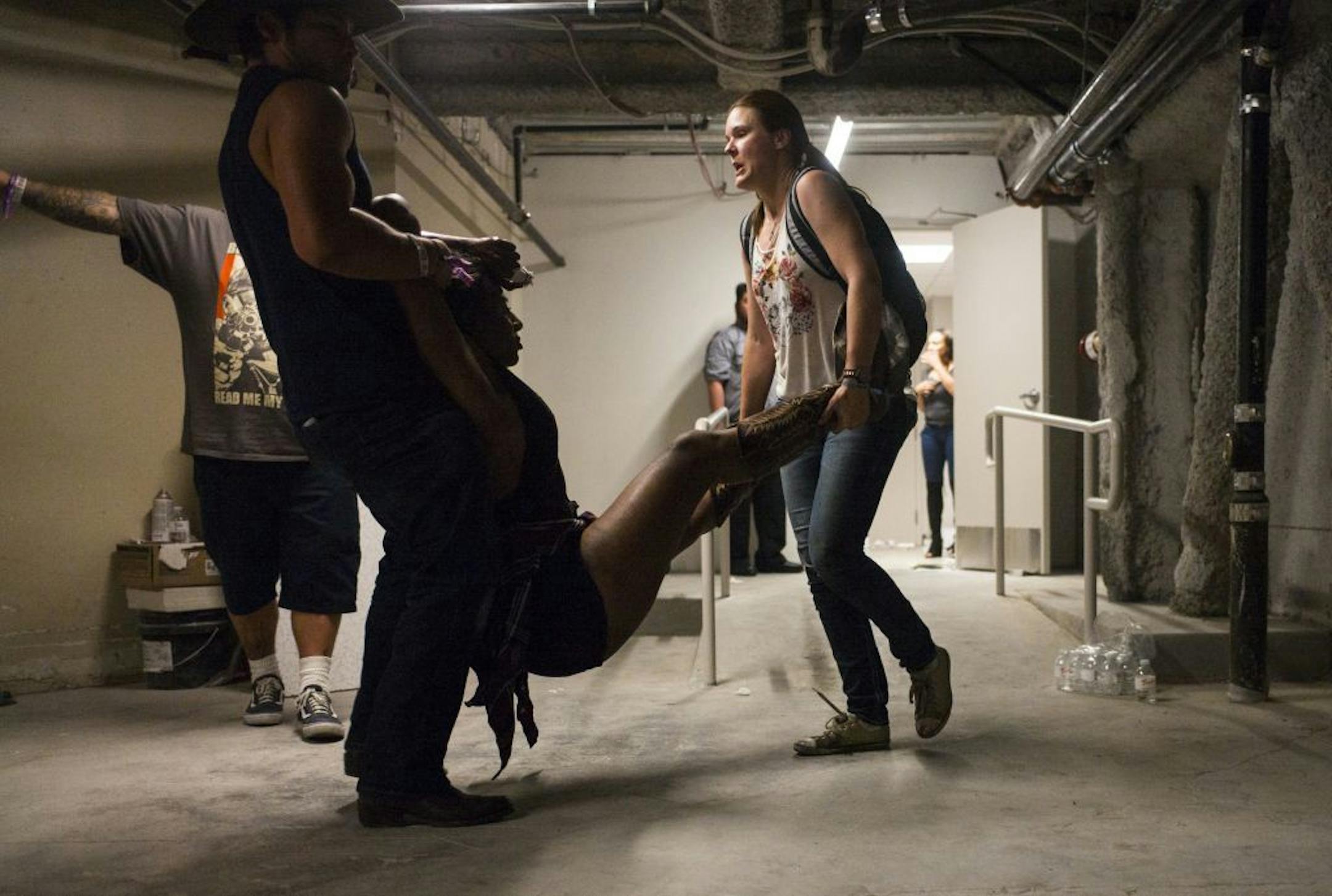 People assist a wounded woman at the Tropicana during an active shooter situation on the Las Vegas Strip in Las Vegas Sunday.