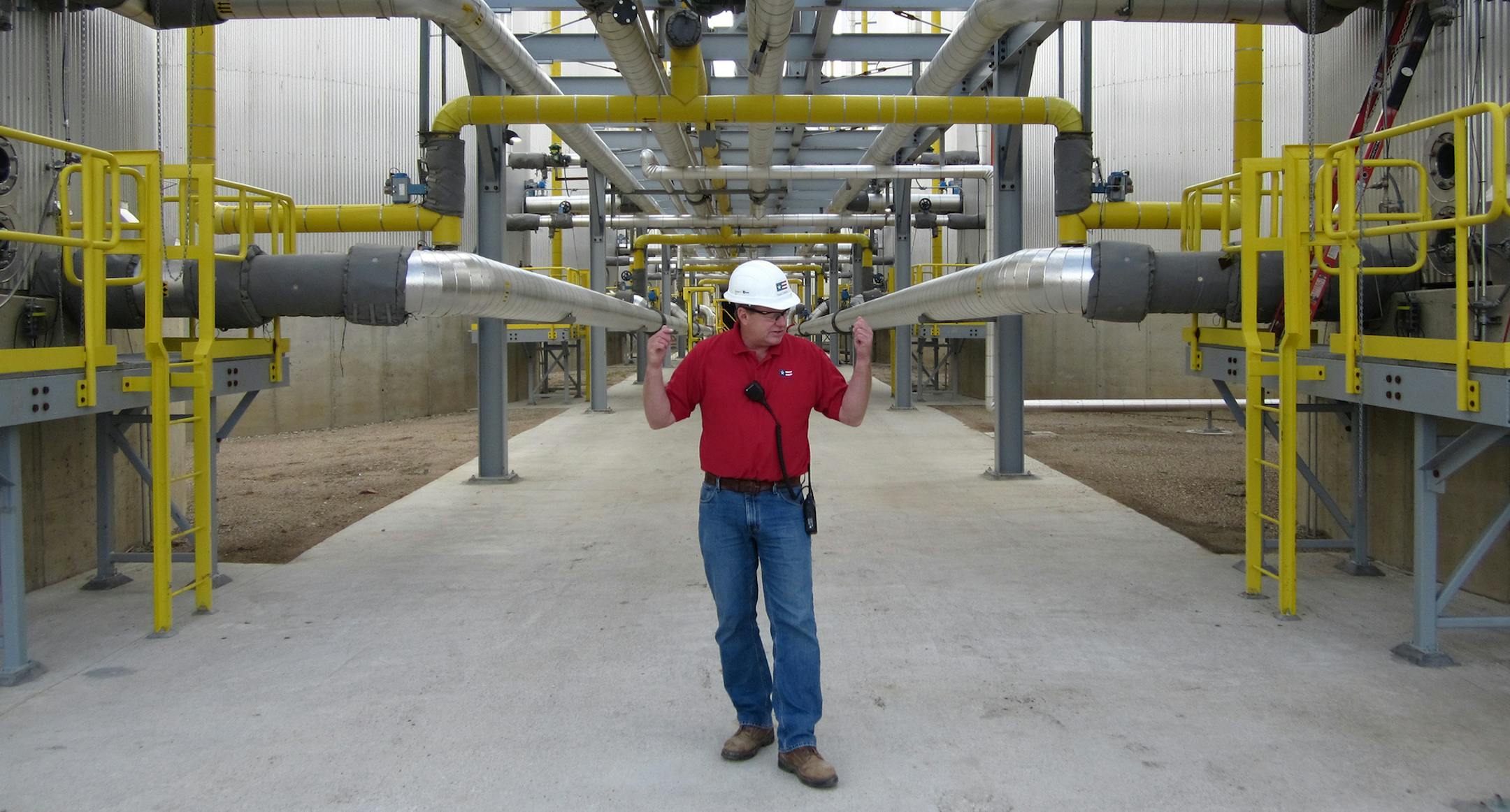 Daron Wilson, general manager of the Poet-DSM cellulosic ethanol plant in Emmetsburg, Iowa, stands in the a complex of pipes and tanks known as ìsaccharification alley.î In this key stage of making ethanol from nonedible parts of corn, sugars locked in the fibers of corn cob and stalks are being extracted using enzymes following a process involving heat and other techniques. Once the sugar is free, it goes on to be fermented and distilled into ethanol. The plant, known as Project Liber
