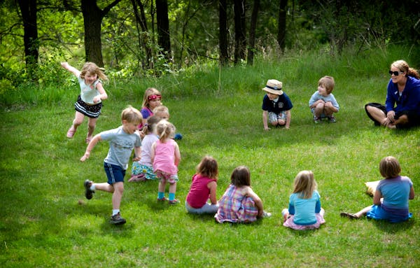 Students sit in a circle and play Duck, Duck, Gray Duck in this file photo.
