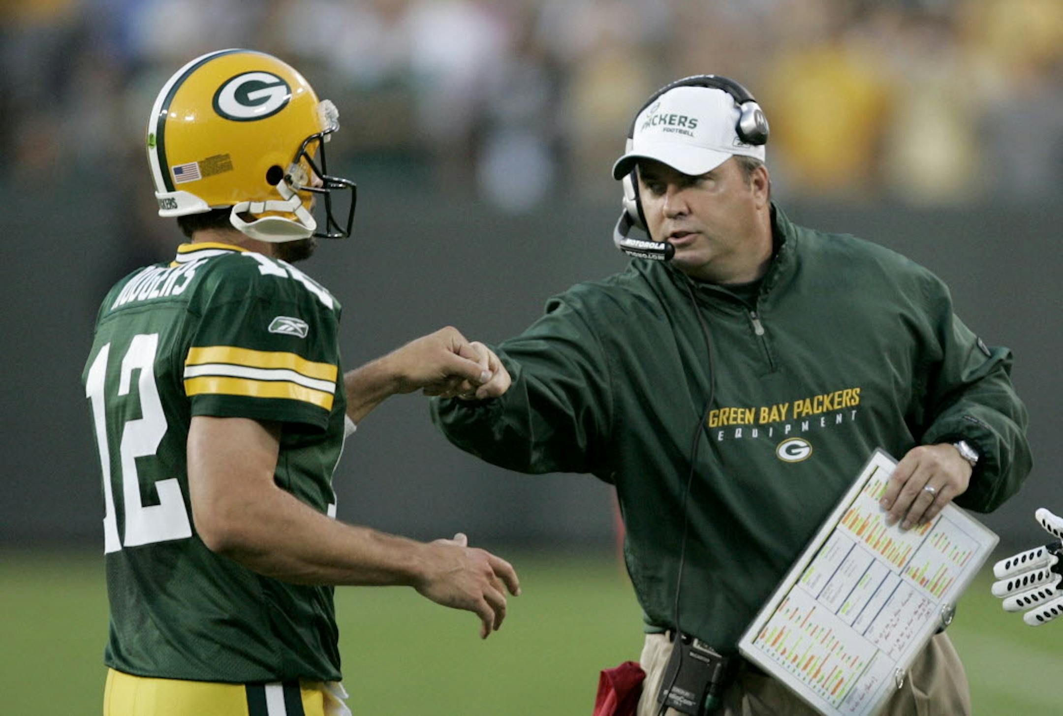 Green Bay coach Mike McCarthy congratulates quarterback Aaron Rodgers after Rodgers completed a 30-yard touchdown pass during Monday's preseasongame against the Bengals,.