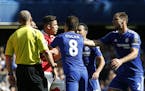 Arsenal's Gabriel, centre,reacts referee Mike Dean sends him off for a second clash with Chelsea's Diego Costa, as Chelsea's Oscar, No 8, and Chelsea'