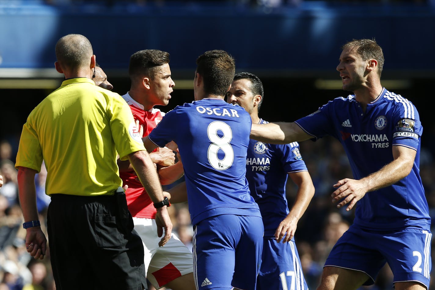 Arsenal's Gabriel, centre,reacts referee Mike Dean sends him off for a second clash with Chelsea's Diego Costa, as Chelsea's Oscar, No 8, and Chelsea's Branislav Ivanovic, right, look on during the English Premier League soccer match between Chelsea and Arsenal at Stamford Bridge stadium in London, Saturday, Sept. 19 2015. (AP Photo/Alastair Grant)