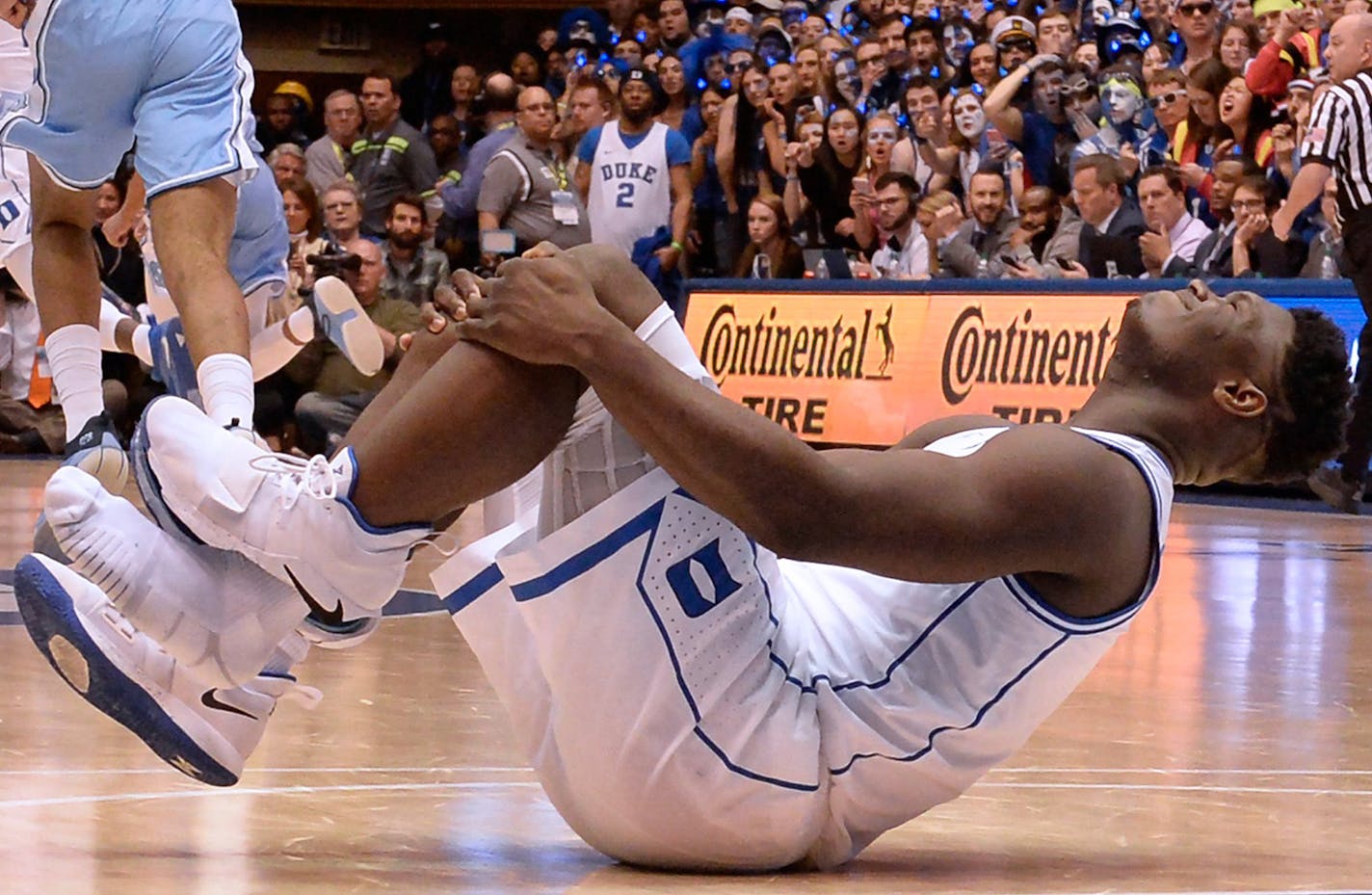 Duke forward Zion Williamson holds his knee after injuring himself and damaging his shoe during the opening moments of the game in the first half on Wednesday, Feb. 20, 2019, at Cameron Indoor Stadium in Durham, N.C. (Chuck Liddy/Raleigh News & Observer/TNS)