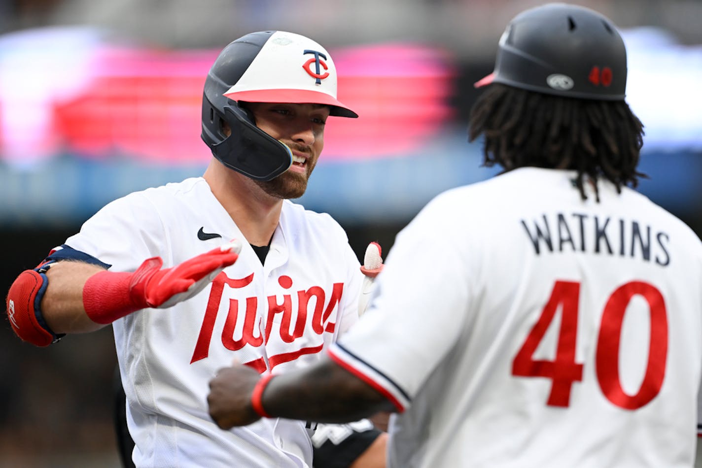 Minnesota Twins second baseman Edouard Julien (47) celebrates a triple with third base coach Tommy Watkins (40) in the bottom of the first inning against the Seattle Mariners Tuesday, July 25, 2023 at Target Field in Minneapolis, Minn.. ] AARON LAVINSKY • aaron.lavinsky@startribune.com