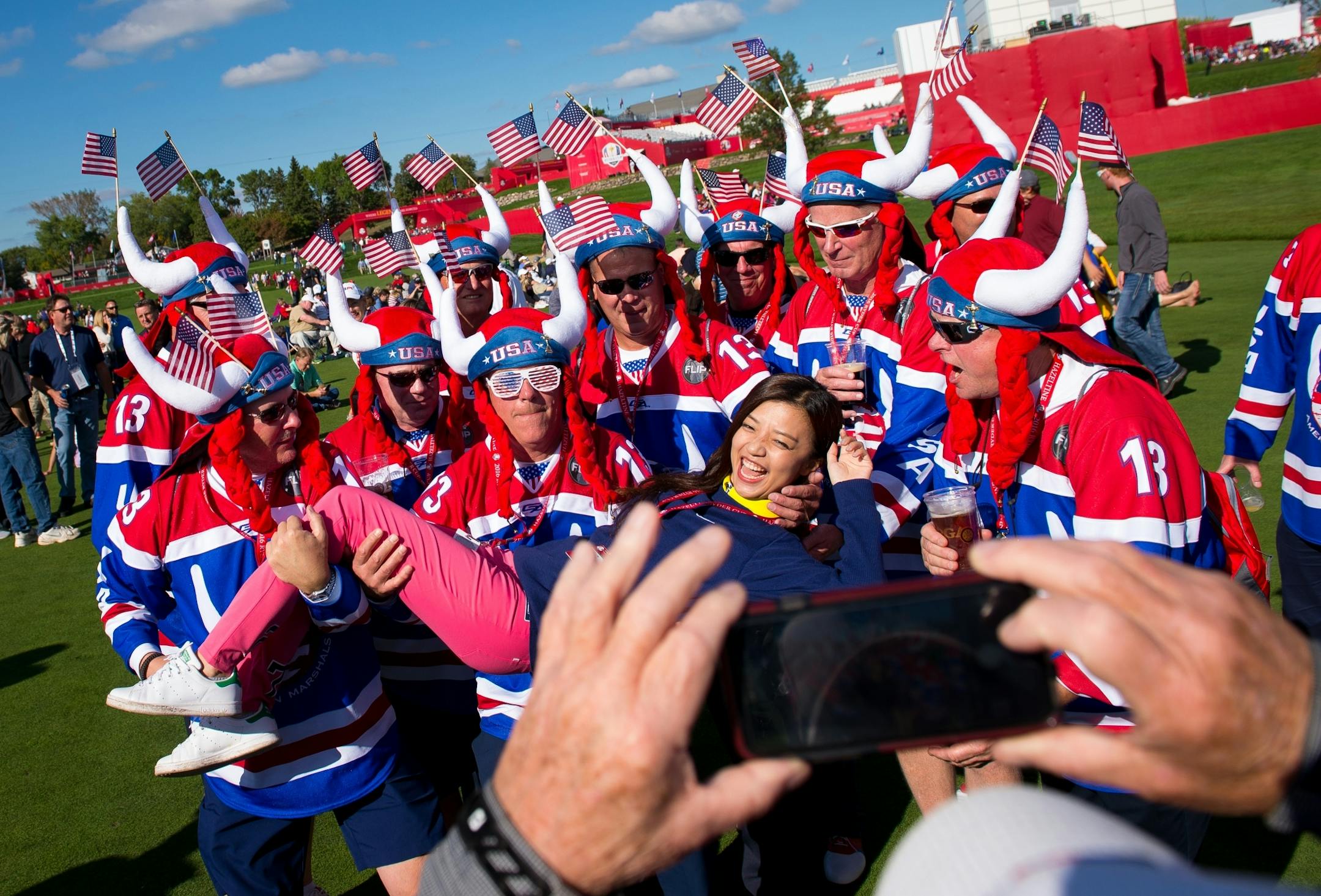 Elin Yang, a Chinese journalist with LeSports Golf, posed for a photo with USA fans before the start of Thursday night's Ryder Cup opening ceremony.