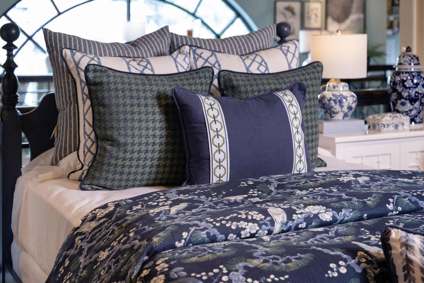 Bed with blue and white linens in different patterns.