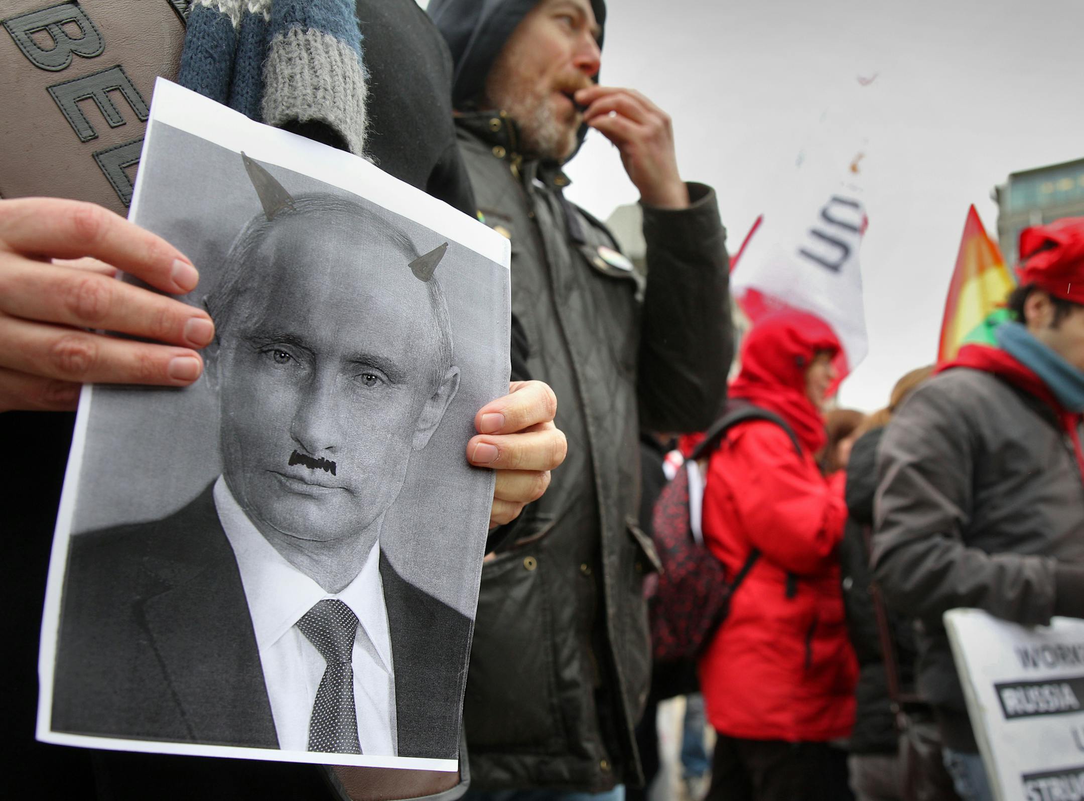A gay rights activist showed a photo of Russian President Vladimir Putin depicted as a devil during a January protest in Brussels.