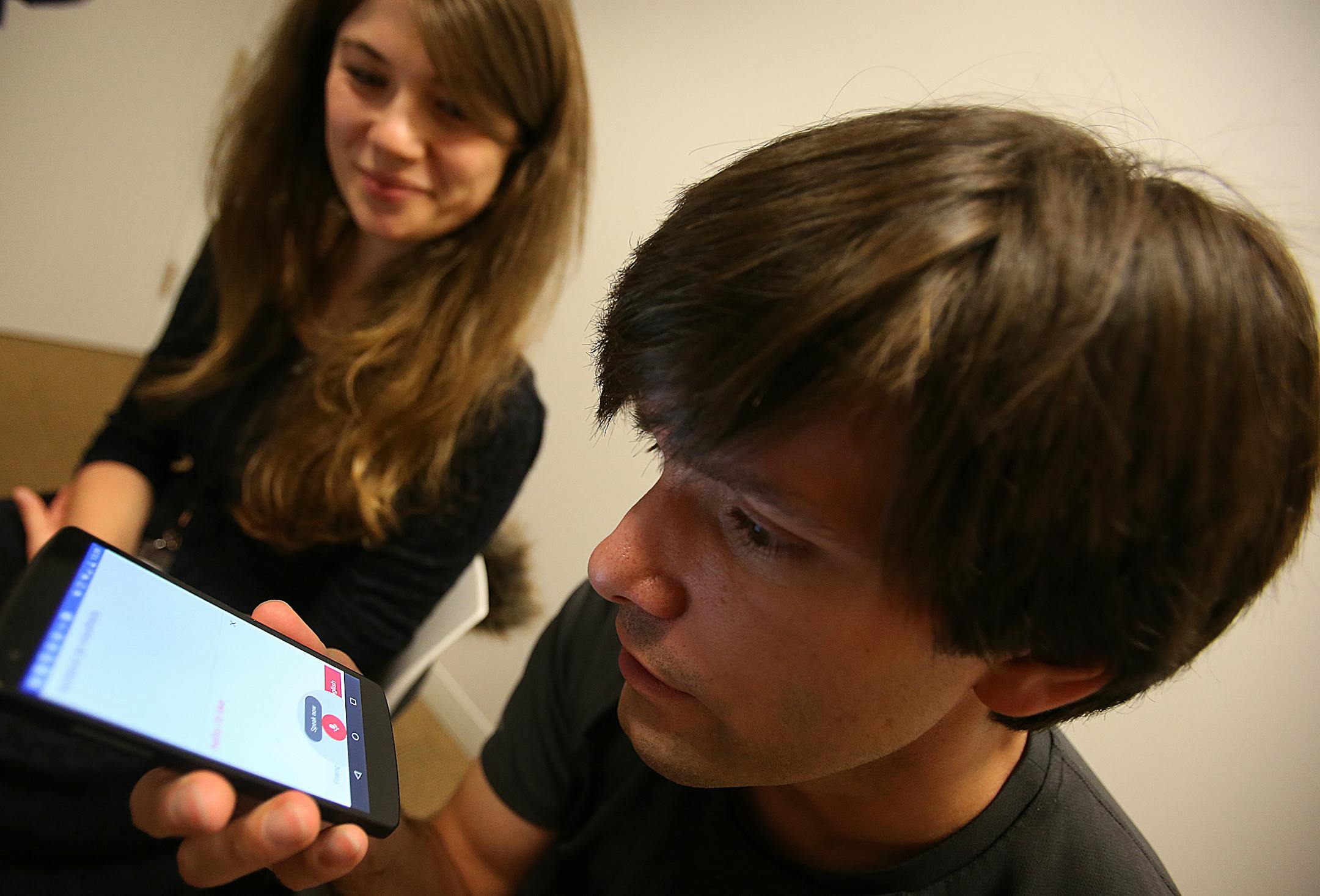 Google product manager Julie Cattiau, left, and software engineer and founder of Word Lens Otavio Good, right, use the Google translate application on a moblie phone during a press confernece on Monday, Jan. 12, 2015 in San Francisco, Calif. (Aric Crabb/Bay Area News Group)