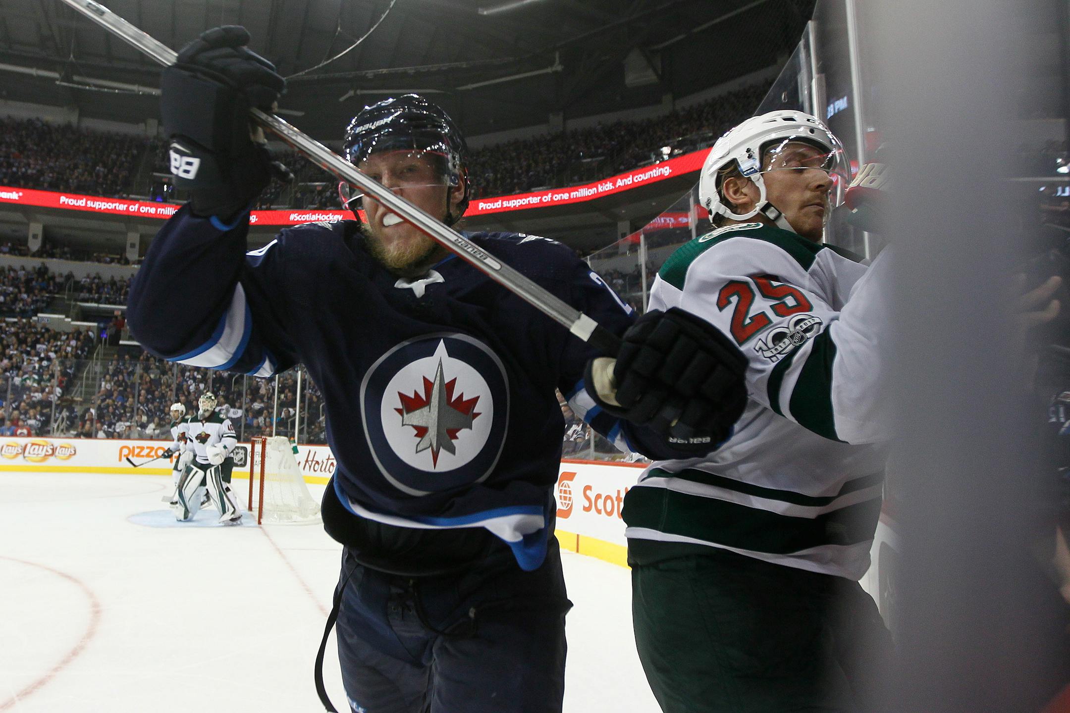 Winnipeg Jets' Patrik Laine (29) checks Minnesota Wild's Jonas Brodin (25) during the second period of an NHL hockey game Friday, Oct. 20, 2017, in Winnipeg, Manitoba. (John Woods/The Canadian Press via AP)