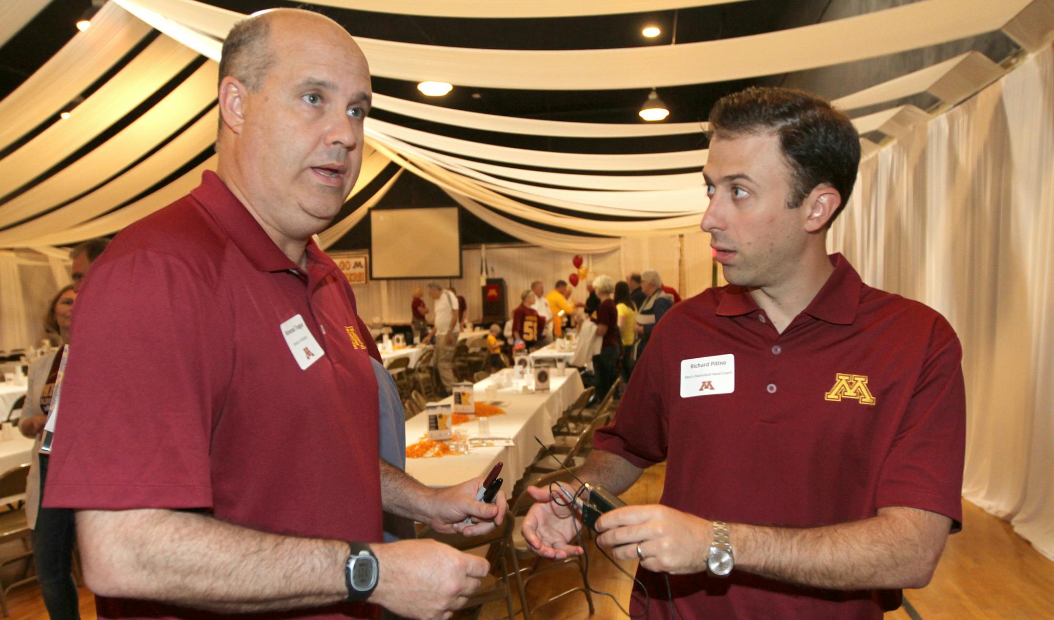 (left to right) University of Minnesota Athletic Director Norwood Teague and Basketball Coach Richard Pitino handed off mics for a TV interview, during the University of Minnesota athletics big spring/summer caravan stop in New Ulm, in which administrators and coaches visited several non-metro sites to build bridges and potentially cultivate donors. Photographed on 5/17/13, New Ulm Minnesota.] Bruce Bisping/Star Tribune Norwood Teague, Richard Pitino/source.