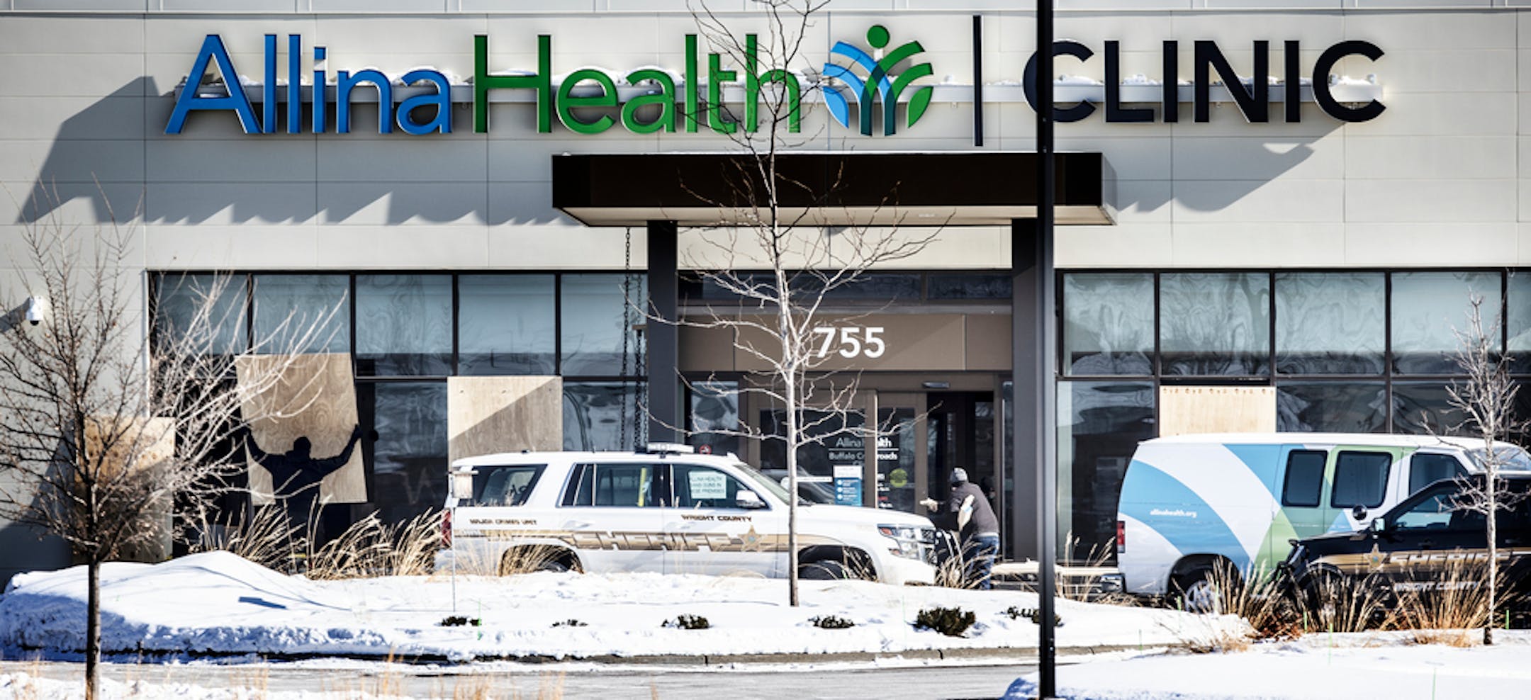 A worker at left ,placed a 4x8 sheets of plywood over windows that were shot out yesterday at Allina Health Clinic Wednesday February 10, 2021 in Buffalo, MN .] Jerry Holt •Jerry.Holt@startribune.com