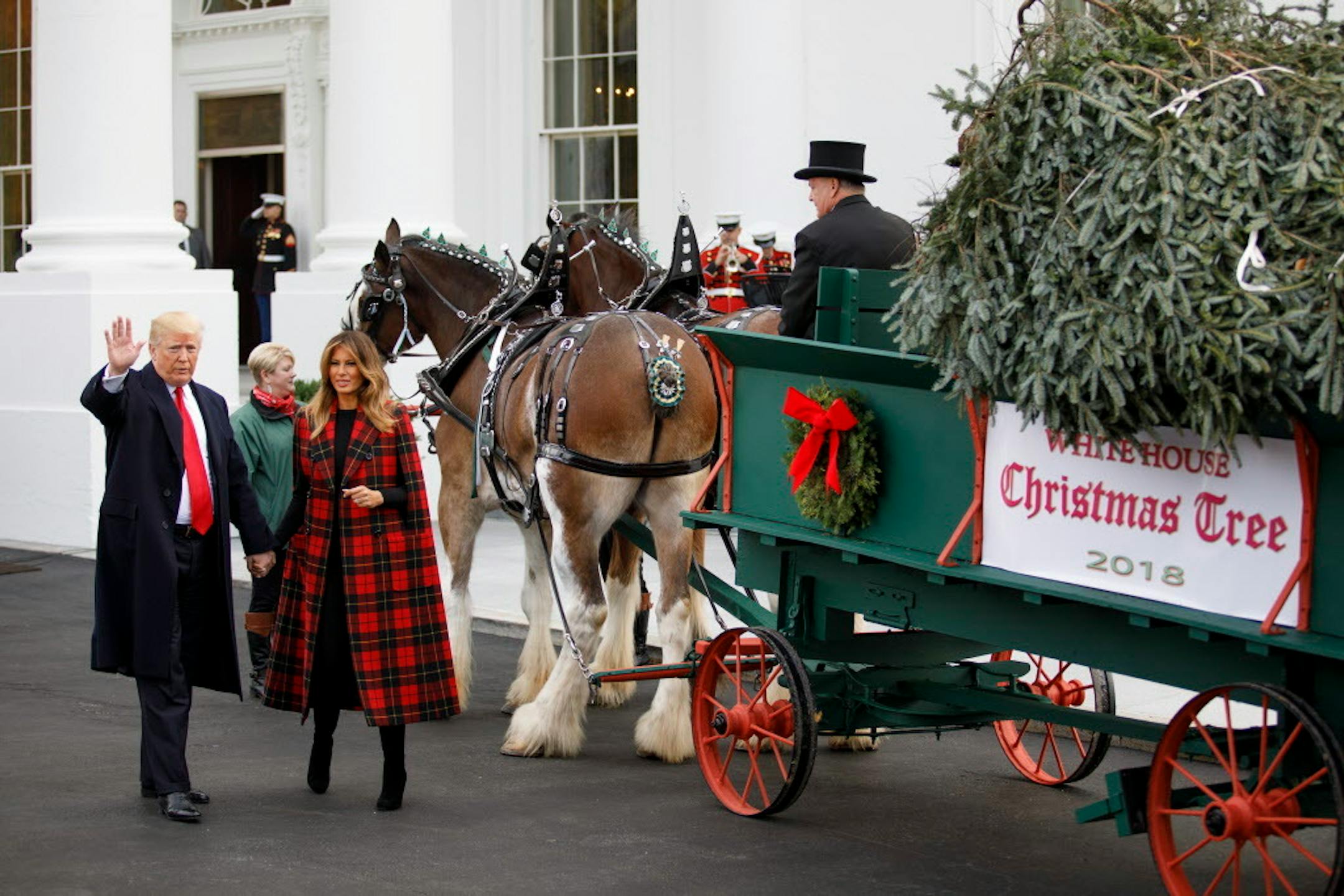President Donald Trump and First Lady Melania Trump watch the delivery of the White House Christmas tree onto the North Lawn driveway in Washington, Nov. 19, 2018.