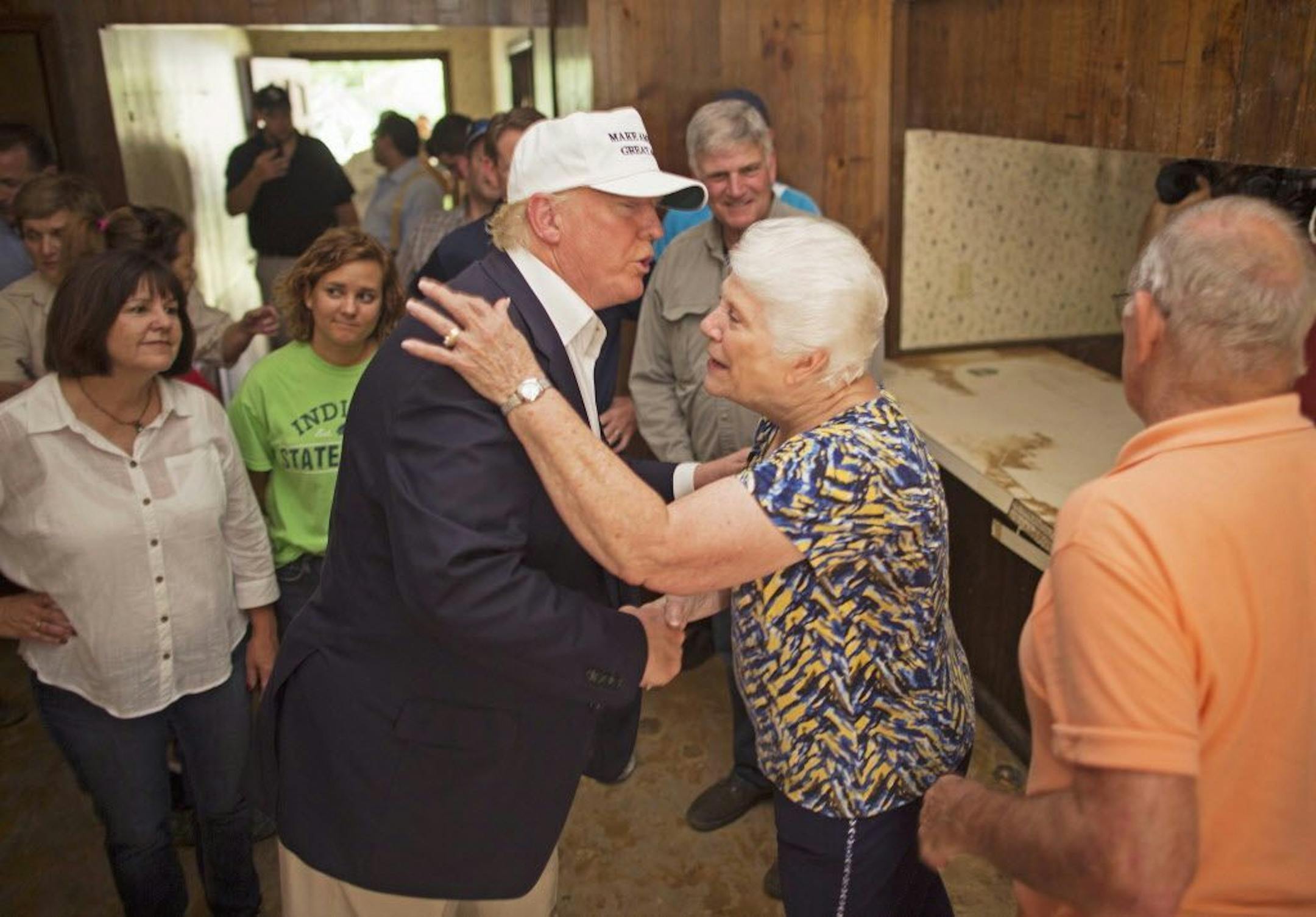 Republican presidential candidate Donald Trump, center, comforts flood victim Olive Gordan with her husband Jimmy, right, during tour of their flood damaged home in Denham Springs, La., Friday, Aug. 19, 2016.