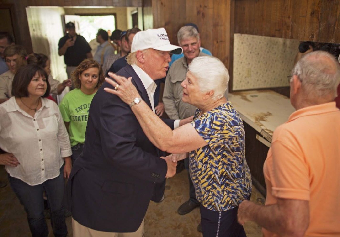 Republican presidential candidate Donald Trump, center, comforts flood victim Olive Gordan with her husband Jimmy, right, during tour of their flood damaged home in Denham Springs, La., Friday, Aug. 19, 2016.