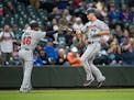 Minnesota Twins' Max Kepler, right, is congratulated by third base coach Tony Diaz as he runs the bases after hitting a solo home run off Seattle Mari