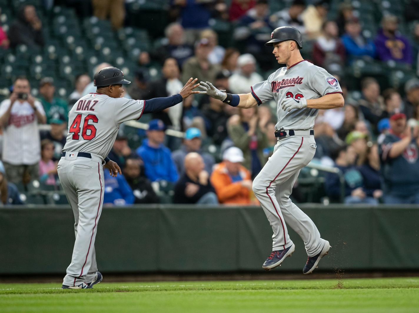 Minnesota Twins' Max Kepler, right, is congratulated by third base coach Tony Diaz as he runs the bases after hitting a solo home run off Seattle Mariners starting pitcher Erik Swanson during the third inning of a baseball game Thursday, May 16, 2019, in Seattle. (AP Photo/Stephen Brashear)