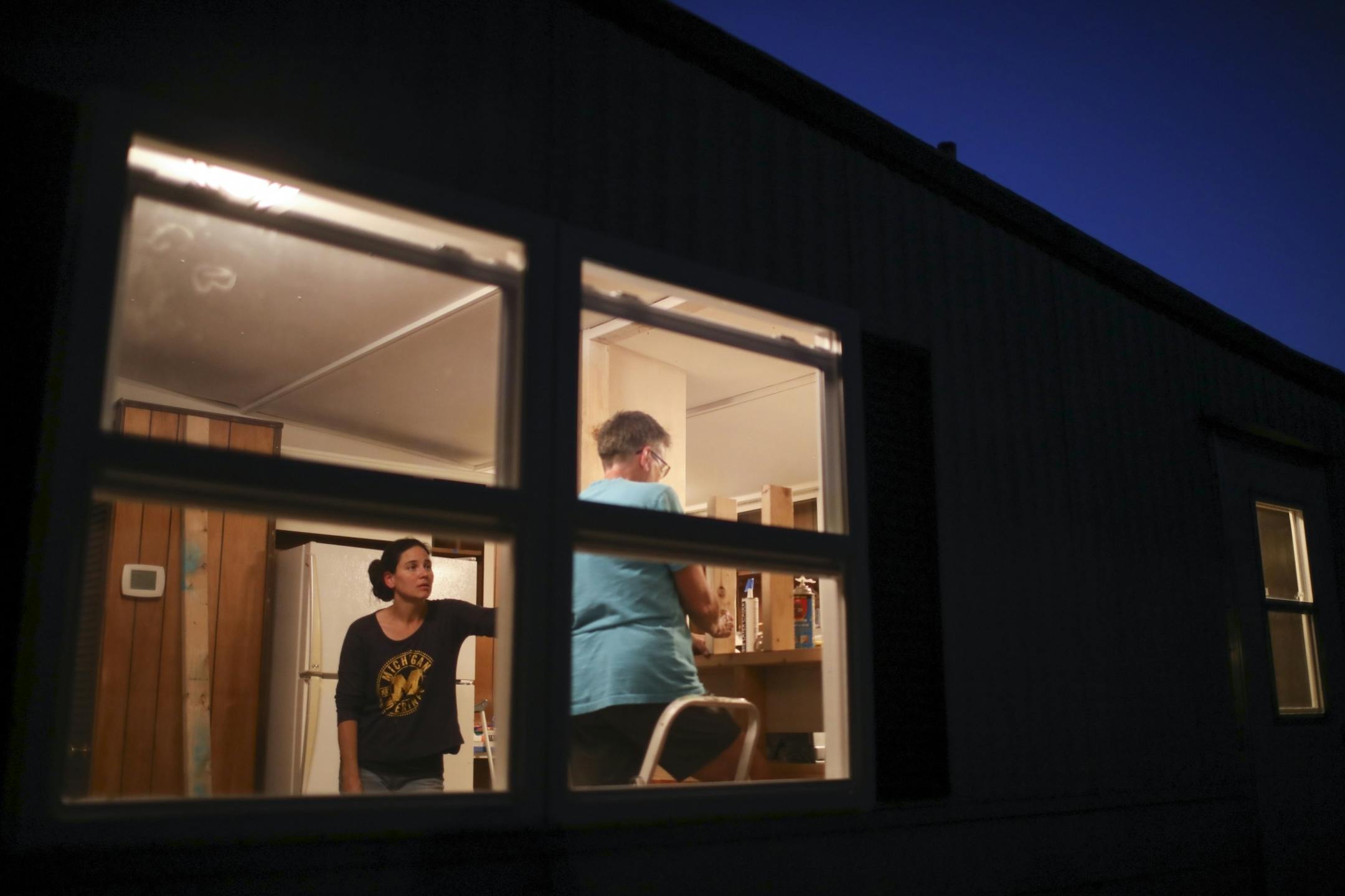Kate Martin, left, visited with Nancy Robinett as she lined up a piece of lumber in a wall she is framing in a mobile home at Lakeside Homes park in New Brighton. A family that had to leave Lowry Grove mobile home park in St. Anthony will move into the unit when volunteers - all St. Anthony residents - have completed the work.