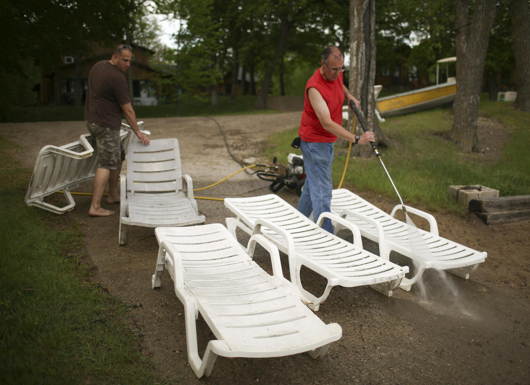 Kregg Wolf, left, helped get his dad, Jim Wolf, set up with lawn chairs to power wash Monday evening. ] JEFF WHEELER &#xef; jeff.wheeler@startribune.com Amy Wolf and her husband, Kregg, bought Lakecrest Resort on Long Lake in Detroit Lakes in January and are preparing for their first summer season as resort owners. With just a few days before the summer season kicks off, they finished getting the place ready on Monday, May 23, 2016.