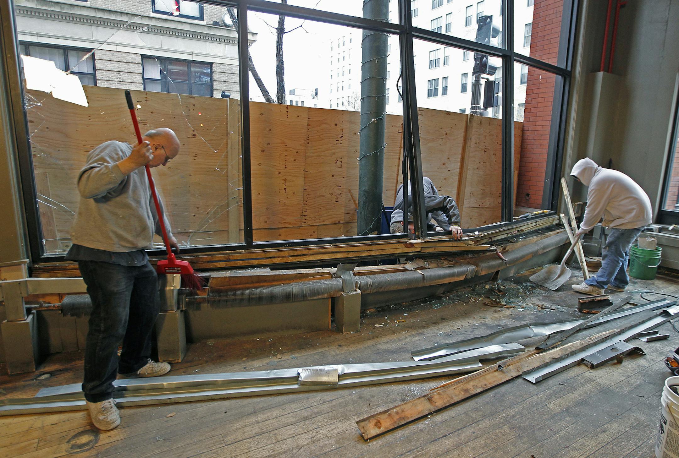 The Bulldog Lowertown's building maintenance manager Gene Klcoke, left, and his son Scotte Klocke cleaned up the scene where a car had gone through last night, Friday, May 2, 2014 in St. Paul, MN. ] (ELIZABETH FLORES/STAR TRIBUNE) ELIZABETH FLORES &#x2022; eflores@startribune.com