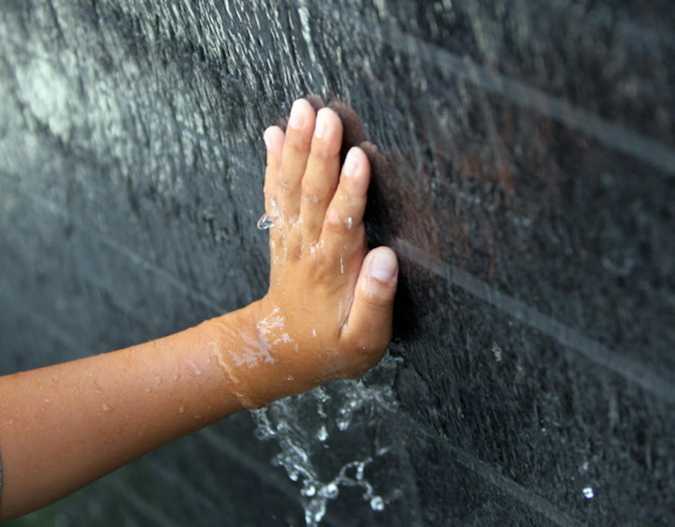 Luis G. Aragon Porcayo touched his name on the survivor wall at the dedication program for the I-35W Bridge Remembrance Garden in Minneapolis, Minn. on August 1, 2011.