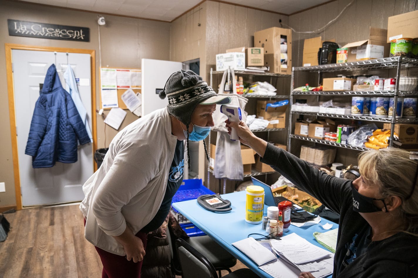 Lori Kadlec, right, co-owner of Kaddy's Kafe in La Crescent took the temperature of dishwasher Katie Konniff when she arrived for a shift.