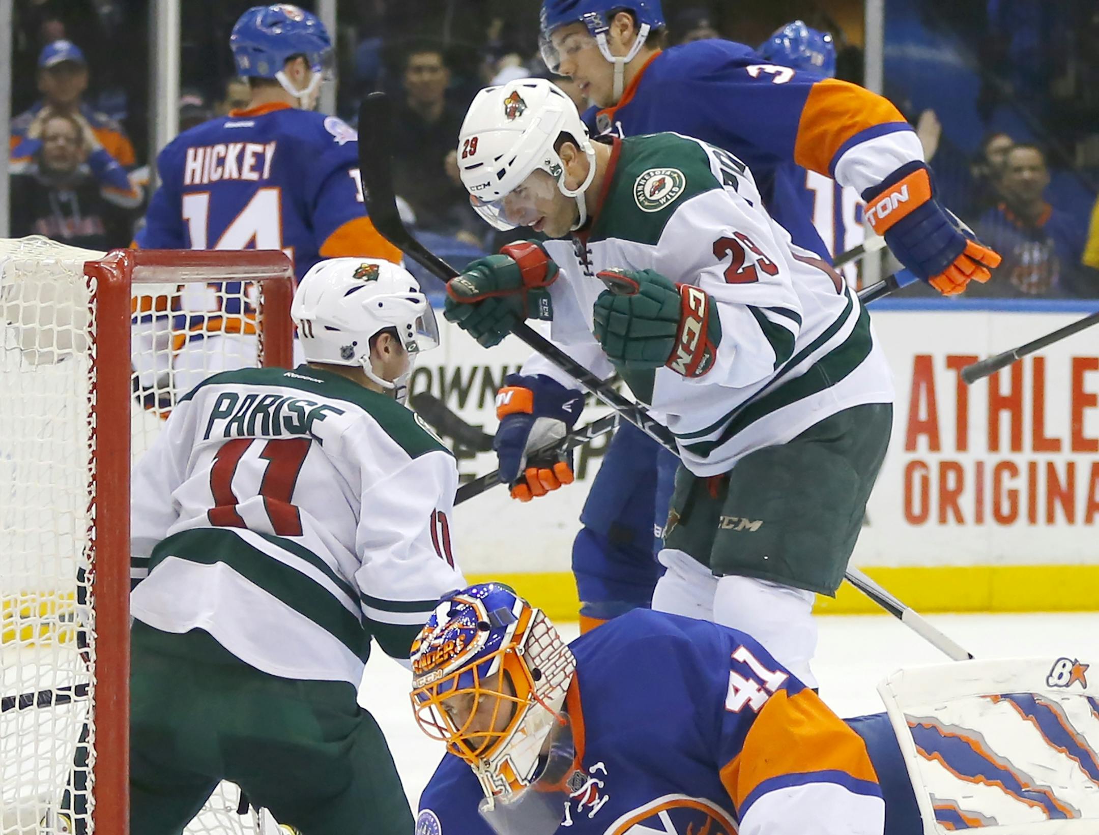 New York Islanders goalie Jaroslav Halak (41) gets up as Minnesota Wild right wing Jason Pominville (29) celebrates a goal scored by Zach Parise (11) to tie the score during the third period of an NHL hockey game Tuesday, March 24, 2015, in Uniondale, N.Y. Minnesota won 2-1 in a shootout. (AP Photo/Paul Bereswill)