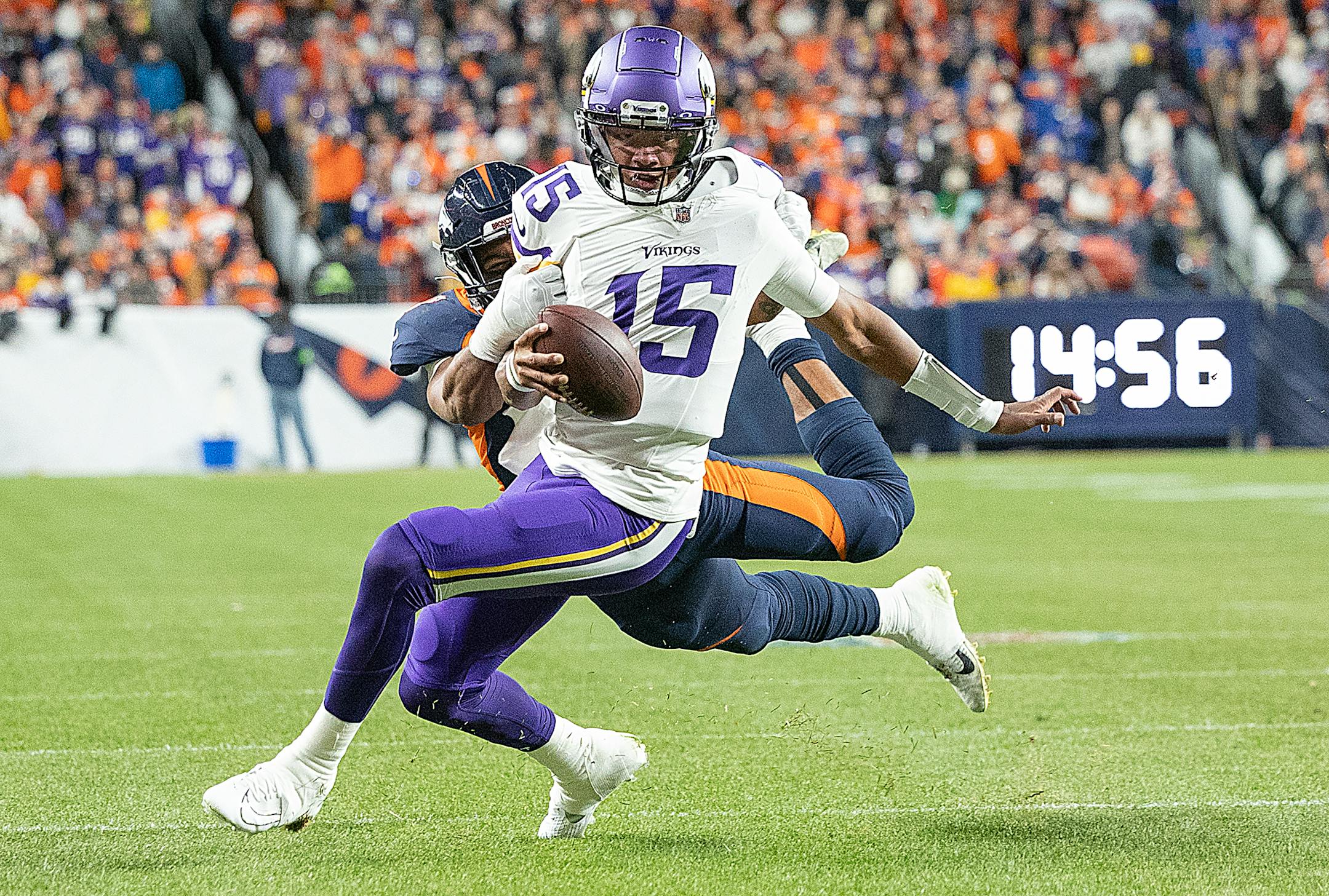 Vikings quarterback Joshua Dobbs (15) breaks the grasps of Broncos linebacker Jonathon Cooper (0) for a short pass to Vikings tight end Josh Oliver (84) for a touchdown in the second quarter at Empower Field at Mile High in Denver, CO., on Sunday, Nov. 19, 2023. ] Elizabeth Flores • liz.flores@startribune.com