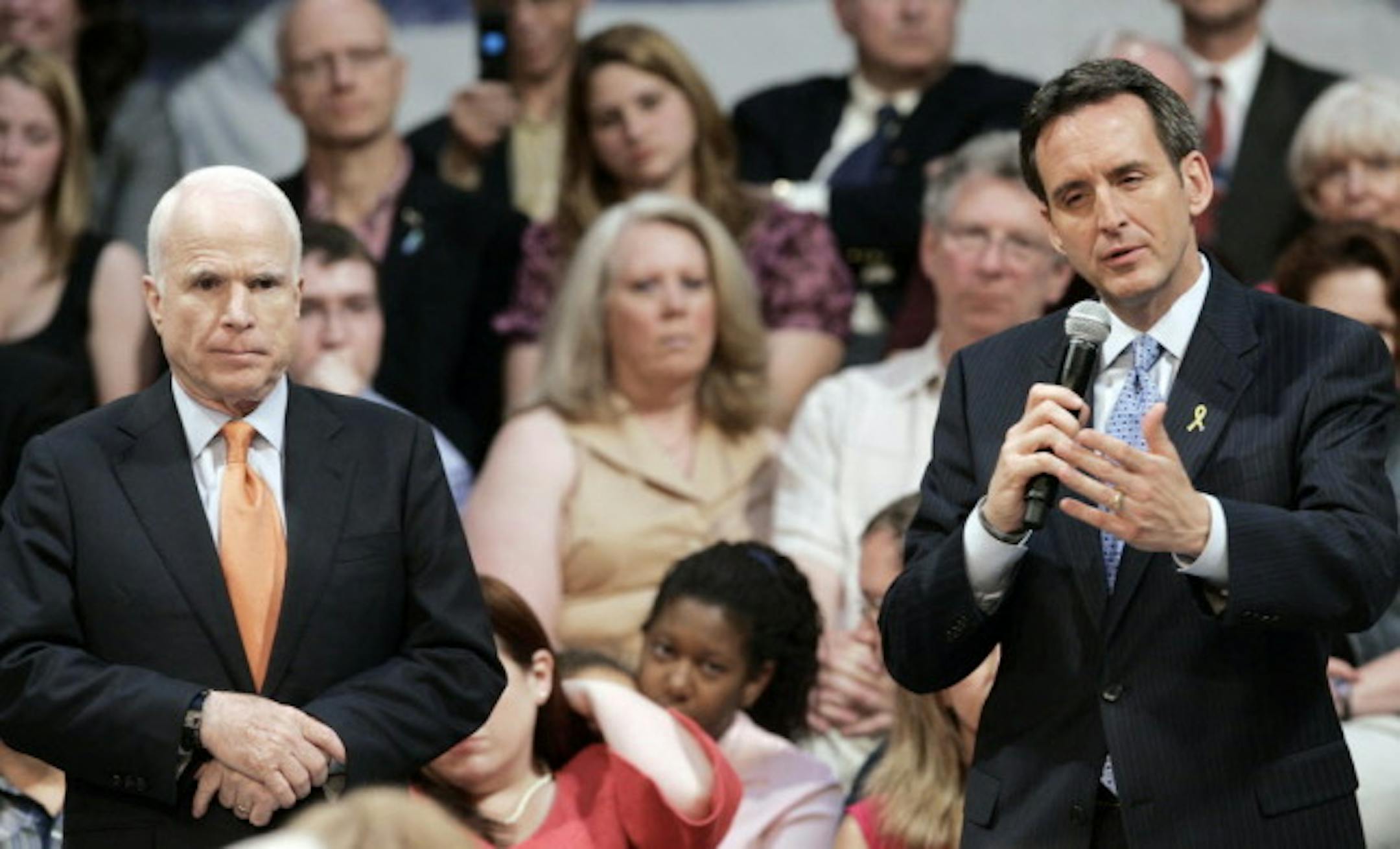 John McCain stands by as Minnesota Gov. Tim Pawlenty addresses a question during a town hall-style meeting Thursday in St. Paul.