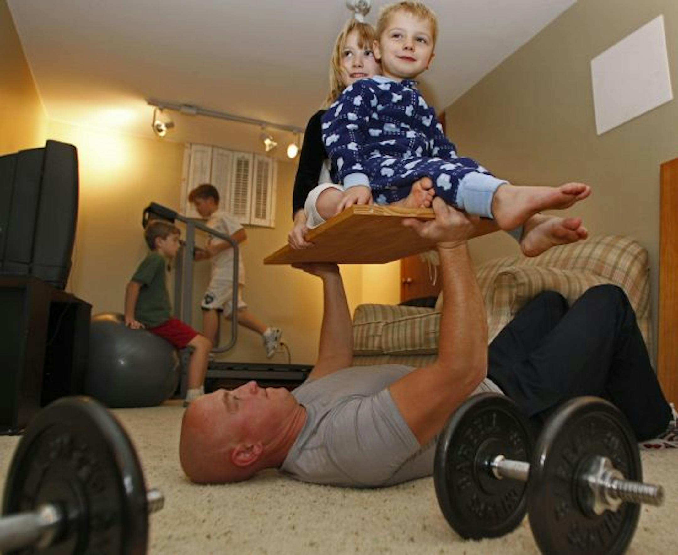 While sons Josh Hayes, 7 worked an exercise ball and CJ Hayes, 9, ran a treadmill, Cullen did chest presses by lifting daughter Julia Hayes, 6 and son Jordan Hayes, 4 on a board.