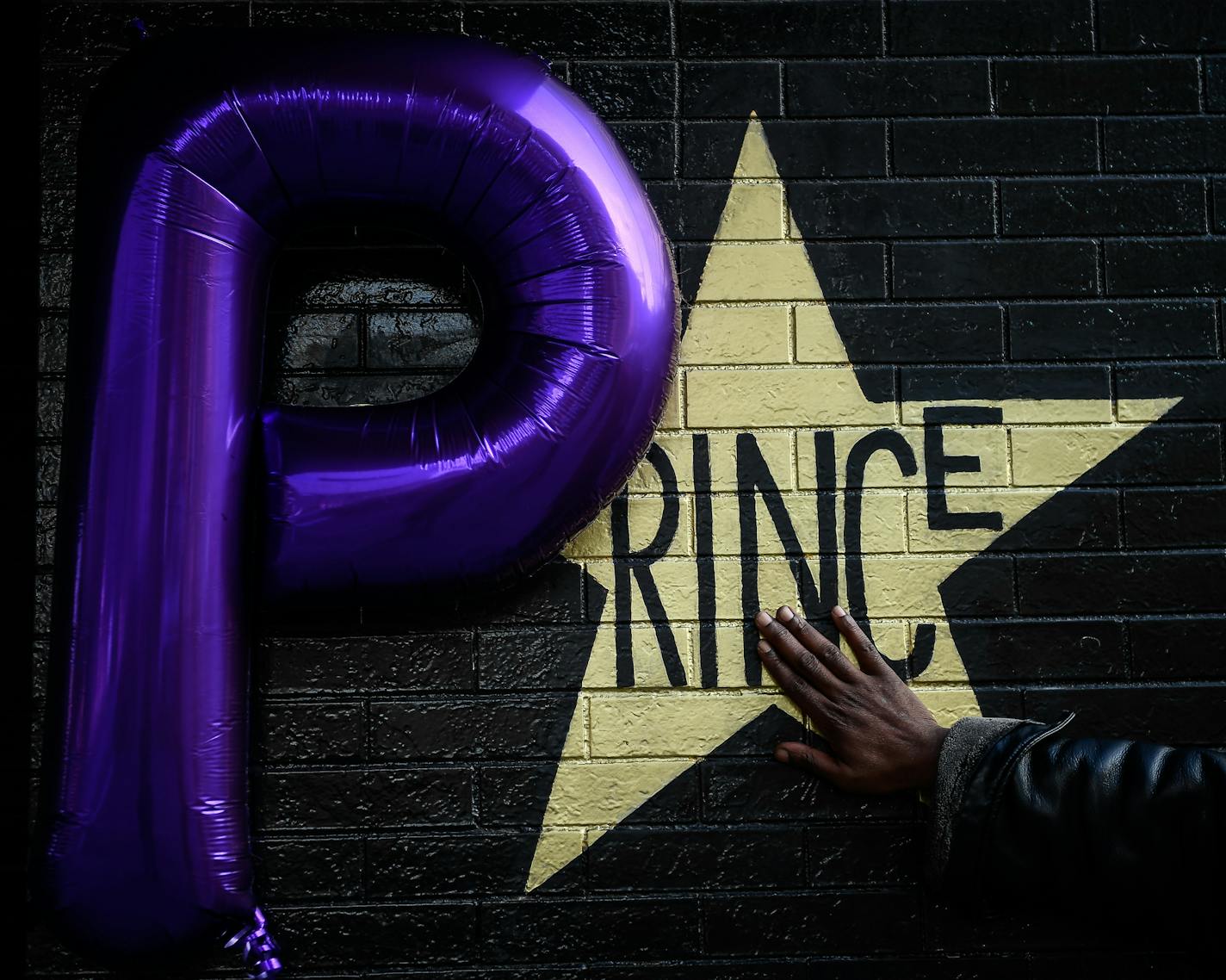 Shannon Nelson, of St. Paul, touched the Prince star on the side of First Avenue Friday afternoon. Nelson says he's a distant relative of Prince. ] AARON LAVINSKY &#xef; aaron.lavinsky@startribune.com Fans gathered outside First Avenue on the one-year anniversary of Prince's death to visit and take pictures with his store adorning the side of the building on Friday, April 21, 2017 in Minneapolis, Minn. ORG XMIT: MIN1704211958290726