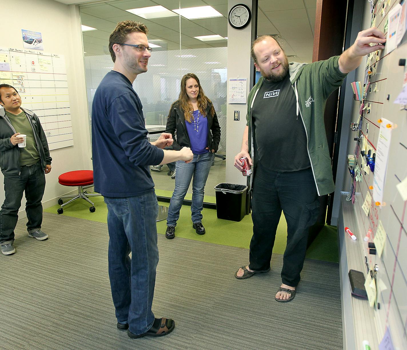 Rich Howard, left, and Nate Anderson, right, led a group in the &#x201c;Scrum&#x201d; room for their daily morning meeting at SPS Commerce, Tuesday, May 19, 2015, in downtown Minneapolis, MN.