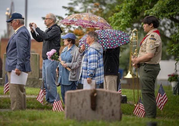 Church of the Assumption parishioners listen as Joe Novak reads the names of 86 veterans buried at the church cemetery during a brief Memorial Day Cer