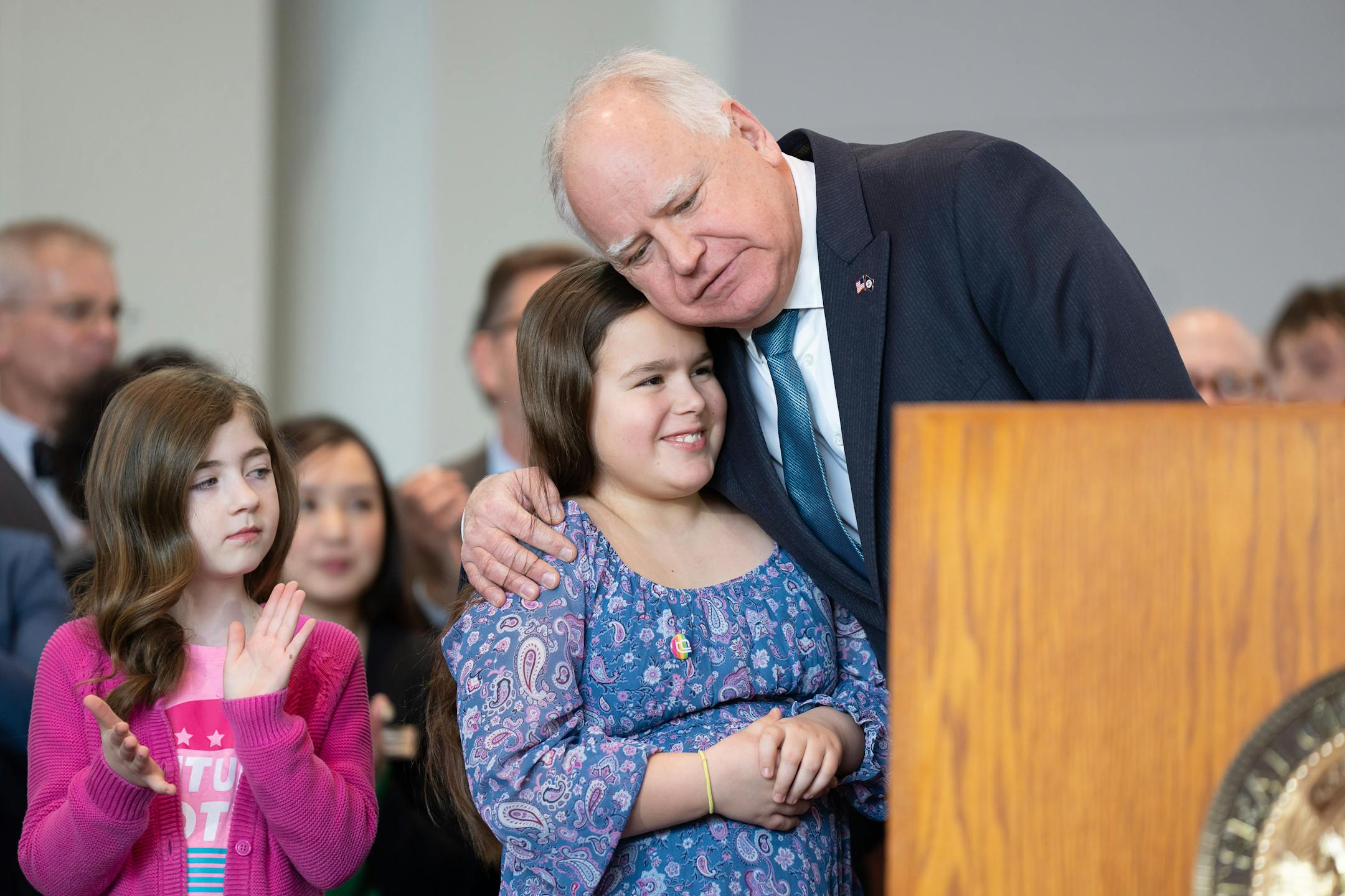 Gov Tim Walz hugged Lt. Gov Peggy Flanagan's daughter Siobhan, on the left is Flanagan's niece Kate Carr.