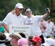 Ernie Els, left, of South Africa, poses with a spectator during the Par 3 contest at the Masters golf tournament Wednesday, April 8, 2015, in Augusta,