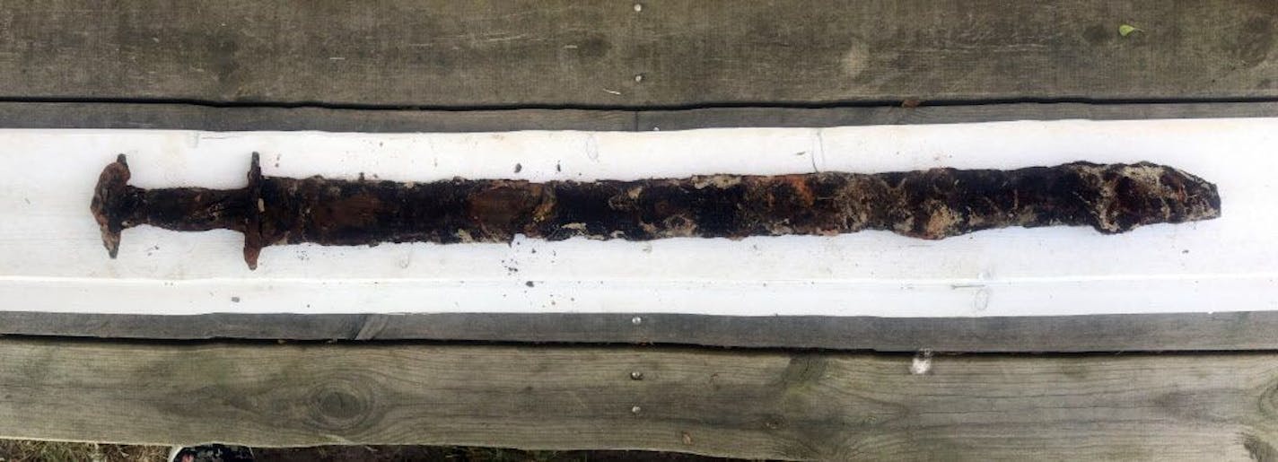 This photo taken in July 2018 and released by the Jonkopings lans Museum on Friday, Oct. 5 2018 shows a pre-Viking era sword in Jonkopings, Sweden. Mikael Nordstrom of the local Jonkoping County museum says 8-year-old Saga Vanecek was helping her father with his boat in the Vidostern lake when she stepped on an 85-centimeter (34-inch) sword in a holster made of wood and leather, believed to be about 1,500 years old.