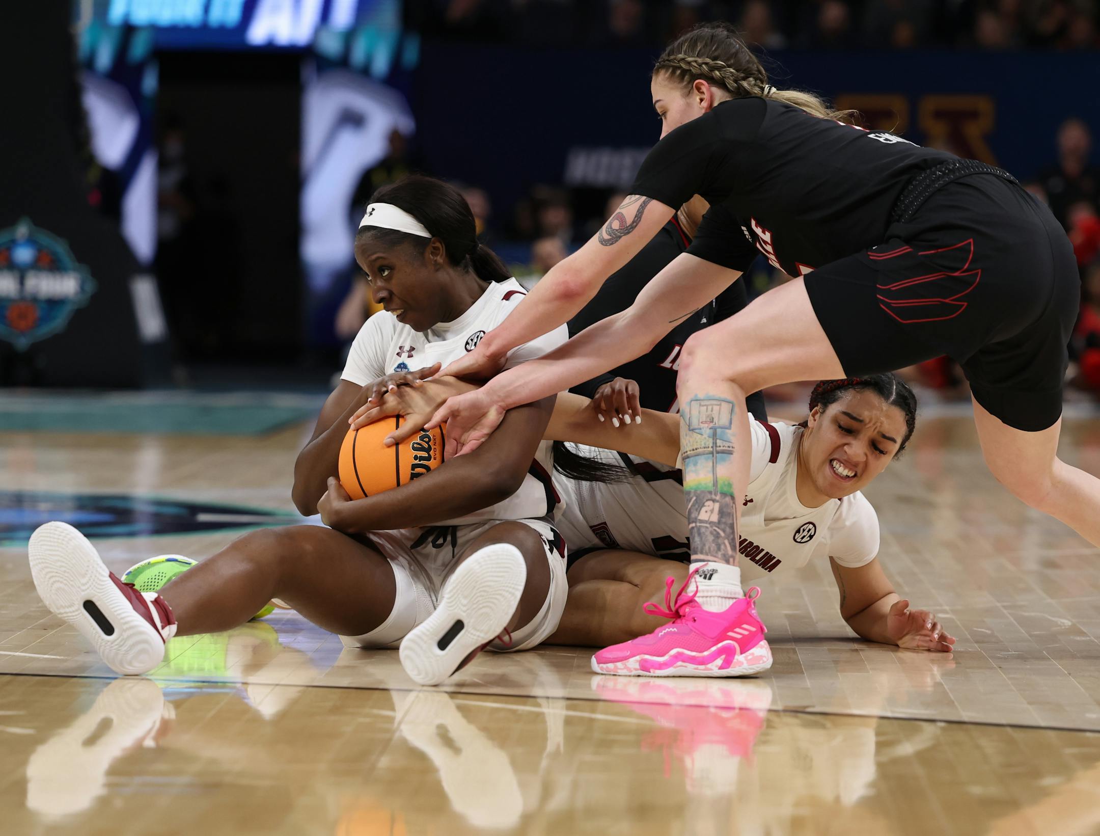 South Carolina forward Laeticia Amihere from left, South Carolina guard Brea Beal and Louisville forward Emily Engstler scramble for the ball.
