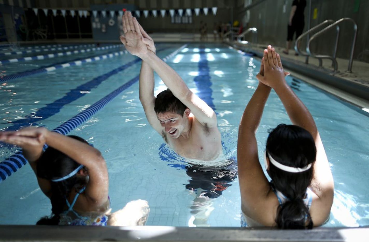 Swim teacher Jack Langree gave Amberly Rosario and Magali Moreno a high five in a swimming position during a swimming class at the YWCA on Monday, June 18, 2012 in Minneapolis, Minn.