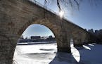 The late afternoon sun cast graphic shadows through the Stone Arch Bridge, across ice covering the Mississippi River. ] JIM GEHRZ &#x2022; james.gehrz
