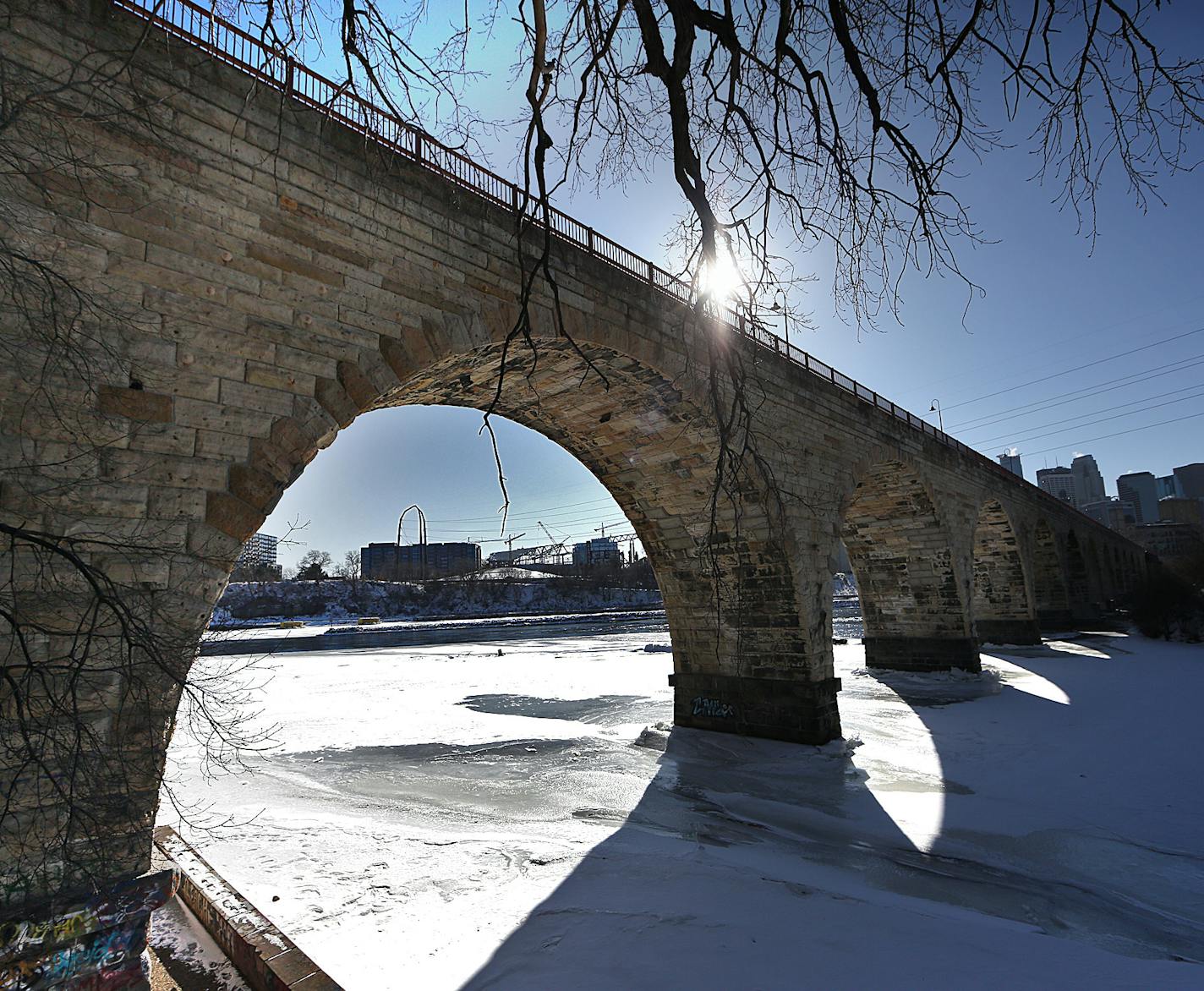 The late afternoon sun cast graphic shadows through the Stone Arch Bridge, across ice covering the Mississippi River. ] JIM GEHRZ &#x2022; james.gehrz@startribune.com / Minneapolis, MN / March 5, 2015 /2:30 PM &#x2013; BACKGROUND INFORMATION: More than 30 years since a foundational plan for riverfront park development prompted huge changes in the St. Anthony Falls area, a new plan takes stock of what's undone, urges correcting what was done wrong and adds new ideas.