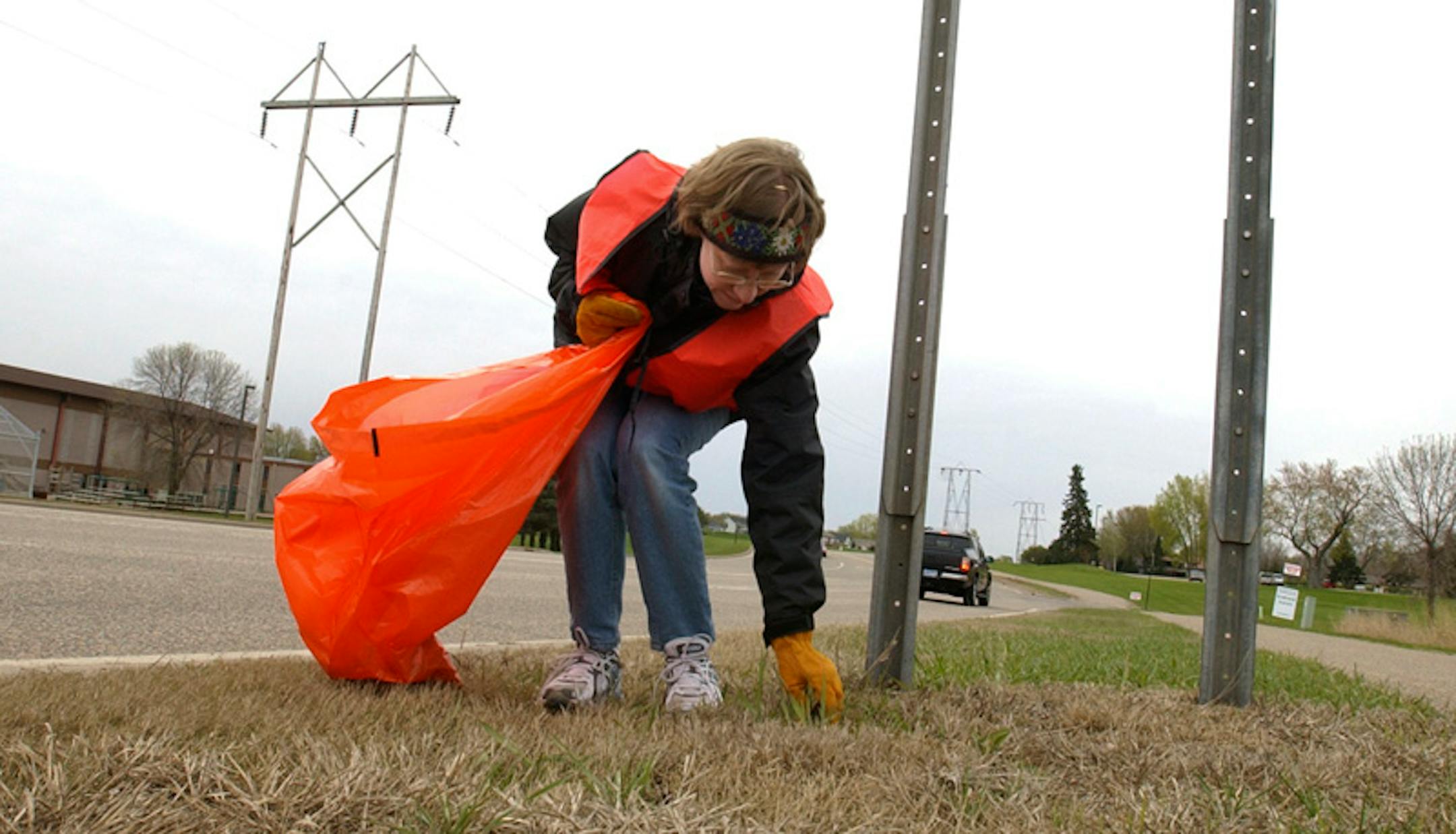 Joey McLeister/Star Tribune Apple Valley,Mn.,Sat.,April 30, 2005--Sarah Wussow picks up trash along Diamond Path Road in Apple Valley. She is an adopt-a-highway volunteer from Rosemount United Methodist Church. (Her group did not get the word to look out for meth lab trash.) GENERAL INFORMATION: Adopt-a-highway volunteers from Rosemount United Methodist Church picked up trash along Diamond Path Road in Apple Valley.