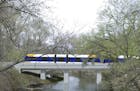 A rendering of the Southwest Light Rail train passing through the Kenilworth Lagoon.